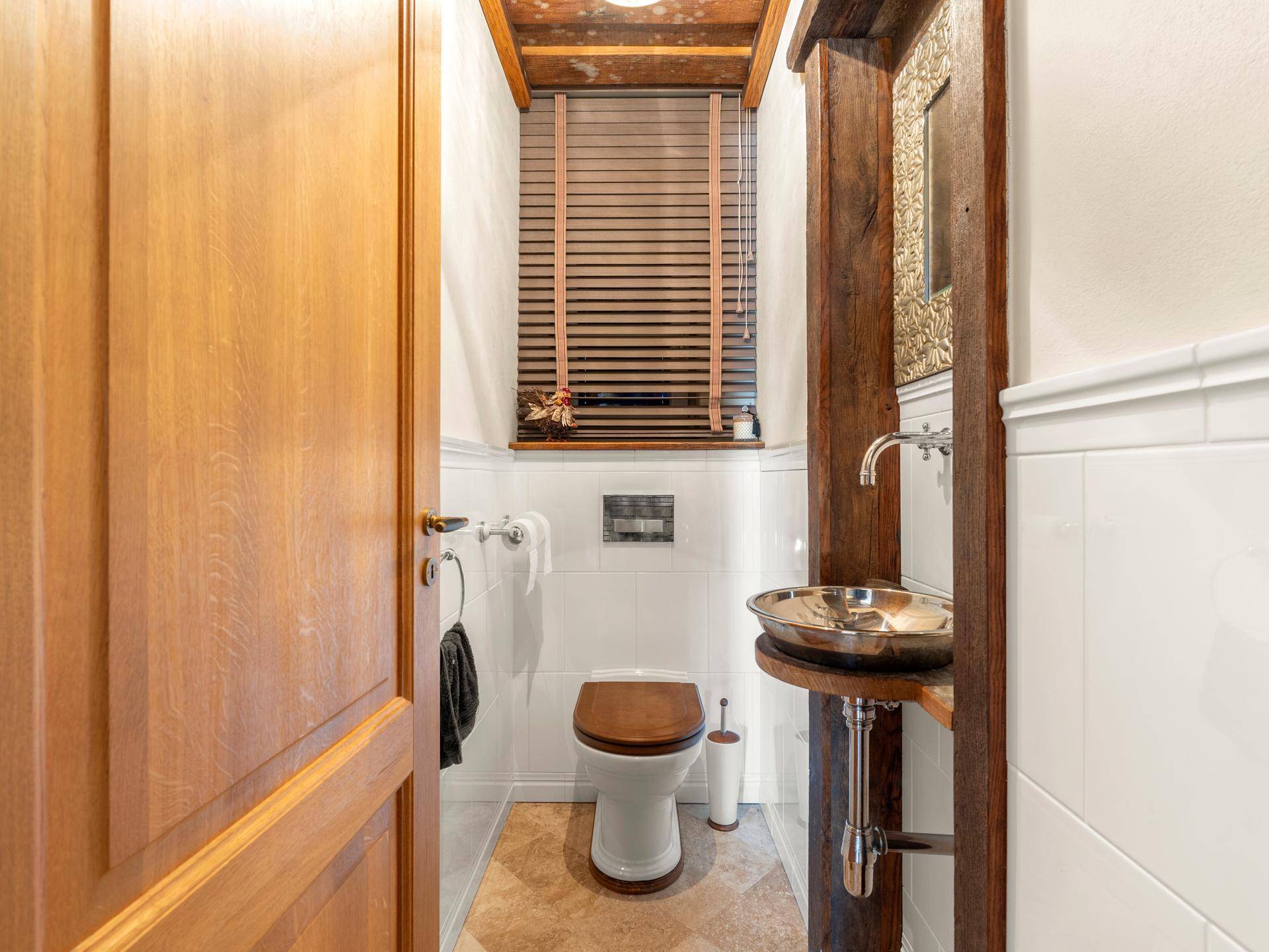 Kleines Gäste-WC mit modernem Waschbecken und Fenster für natürliche Belüftung.