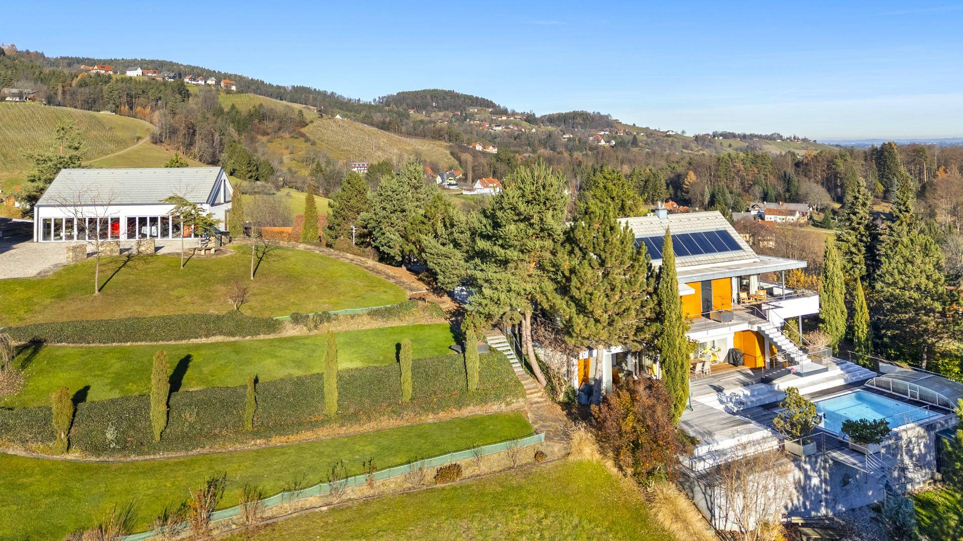 Weitläufige Luftaufnahme des Anwesens mit Pool, Terrassen und malerischer Hügellandschaft im Hintergrund.