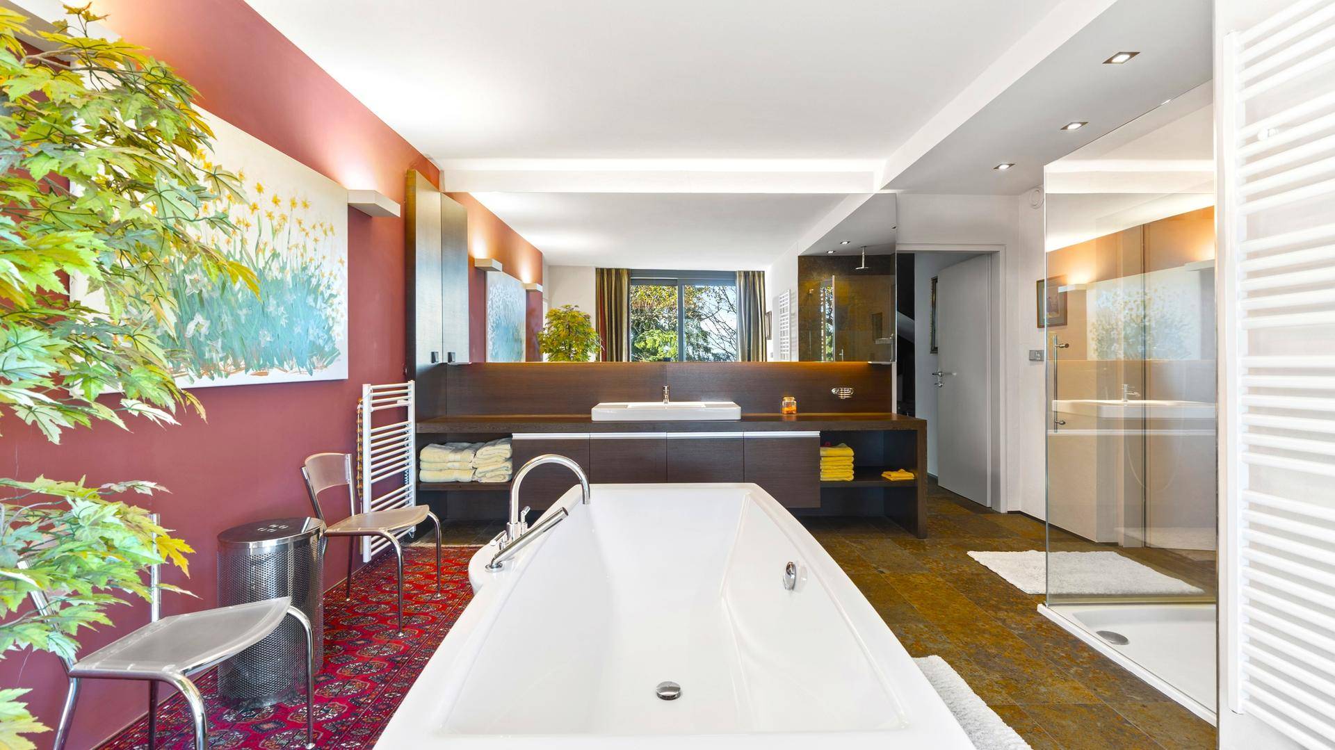 Luxuriöses Badezimmer mit freistehender Badewanne, Doppelwaschbecken und großem Spiegel.