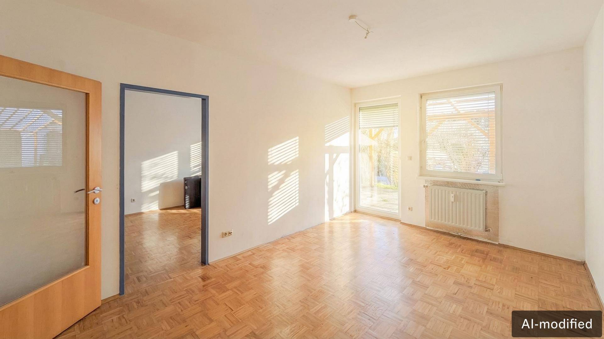 Helles, leeres Zimmer mit Parkettboden, großen Fenstern und viel natürlichem Licht.