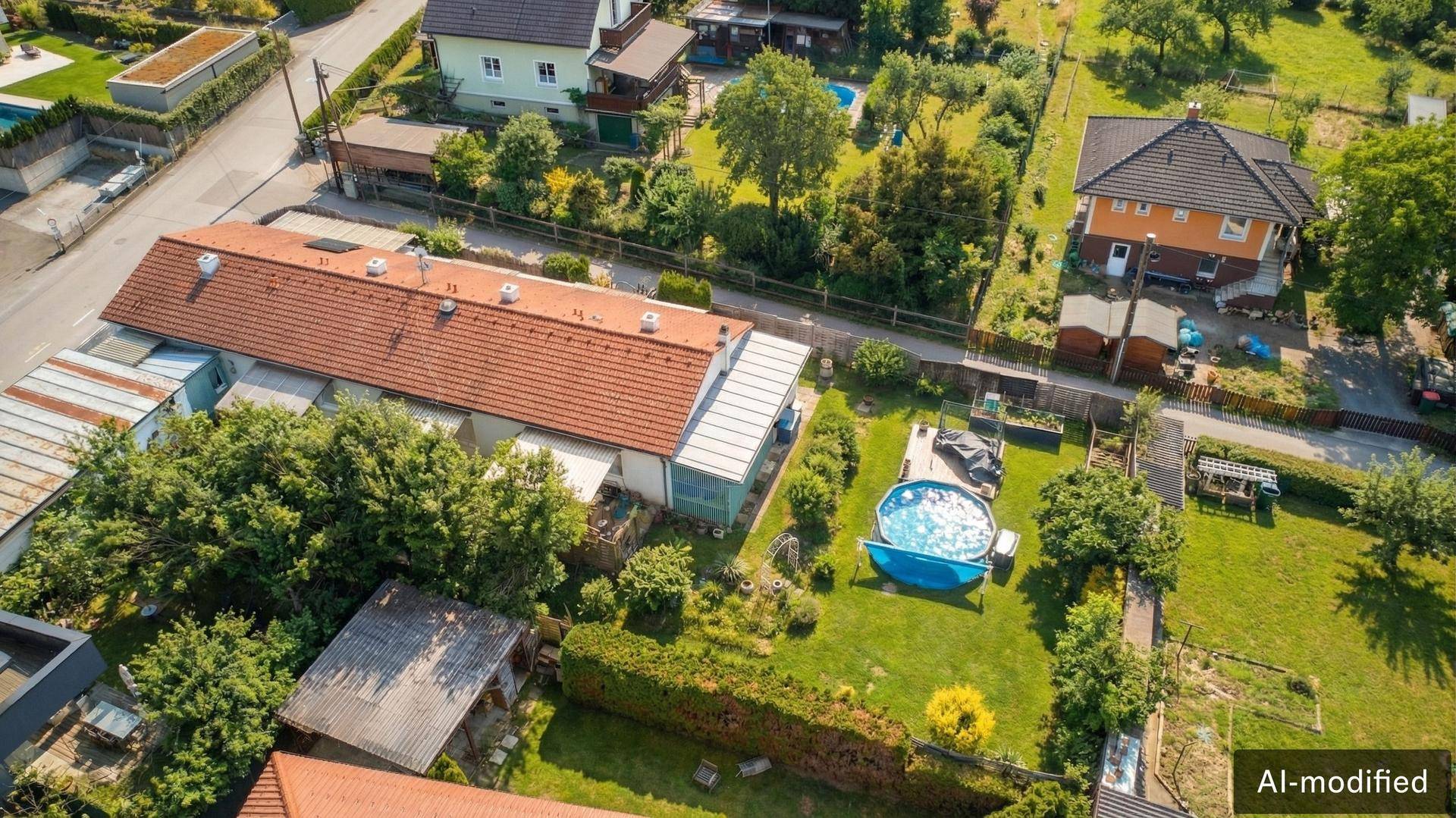 Weitläufige Luftaufnahme einer Wohngegend mit Einfamilienhäusern, Gärten und einem Pool.