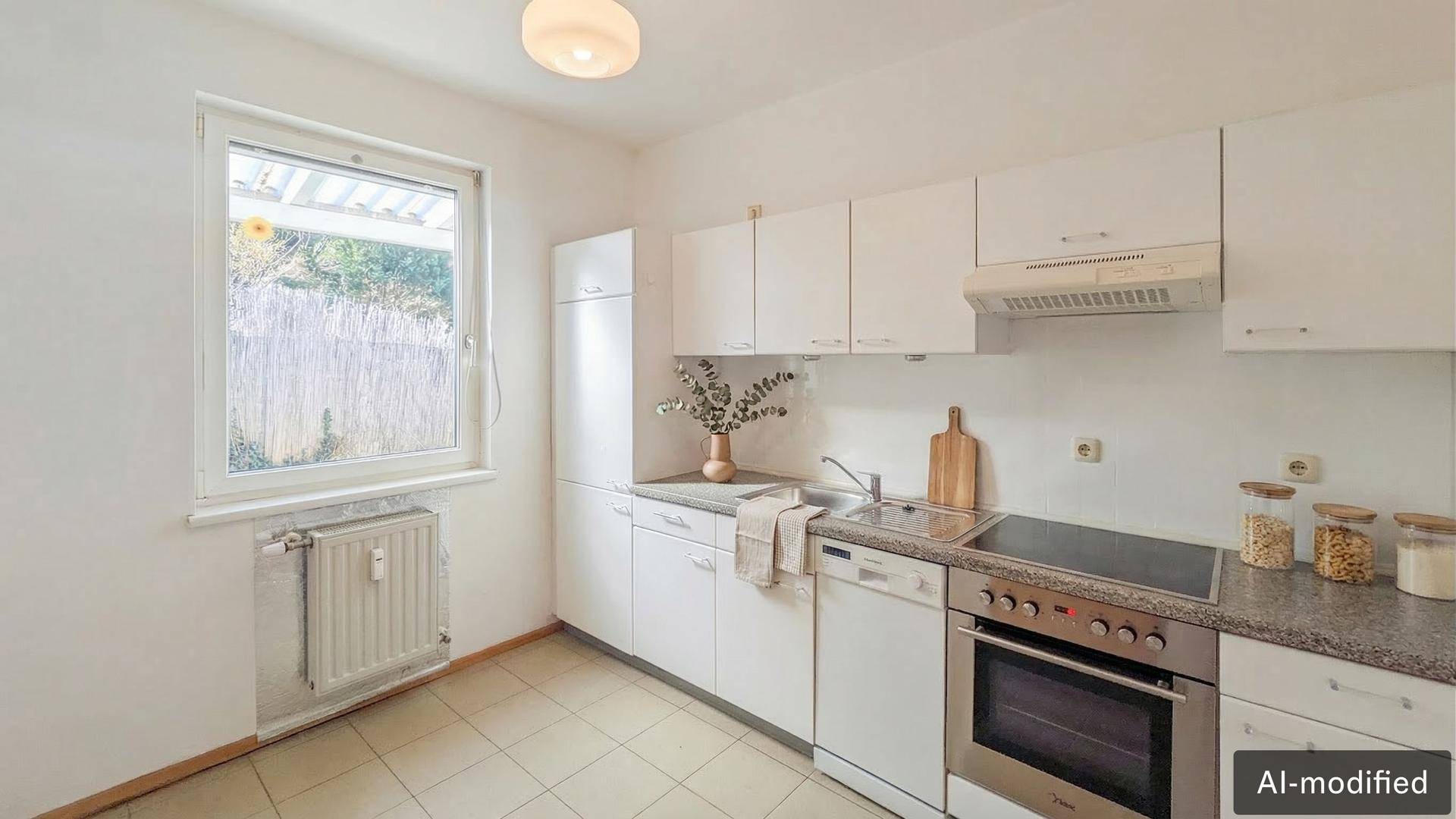 Funktionale weiße Küche mit Einbaugeräten, Fliesenboden und einem Fenster mit Blick ins Grüne.