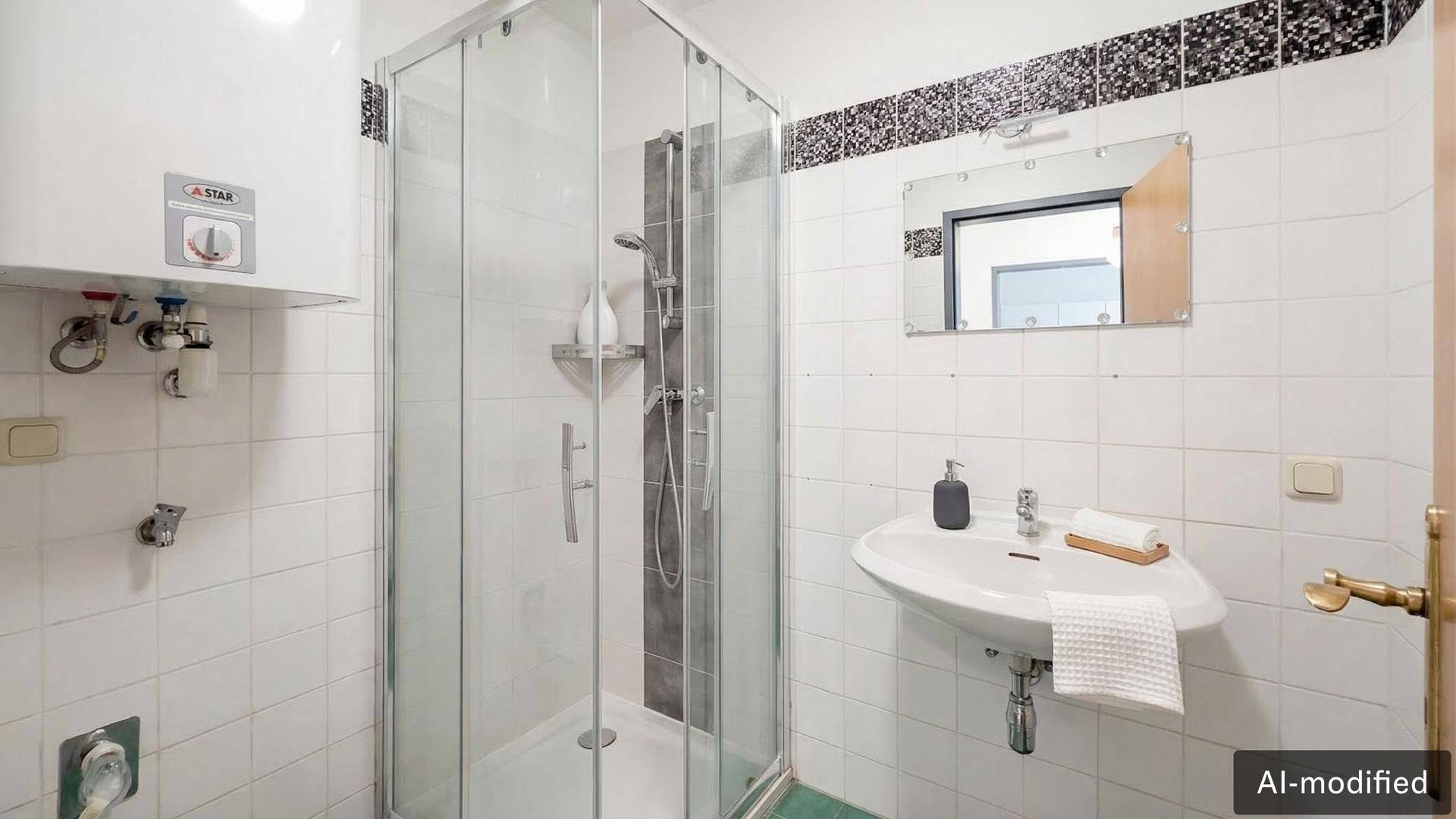 Helles Badezimmer mit Duschkabine, Waschbecken und weißen Fliesen, akzentuiert durch eine Mosaikbordüre.