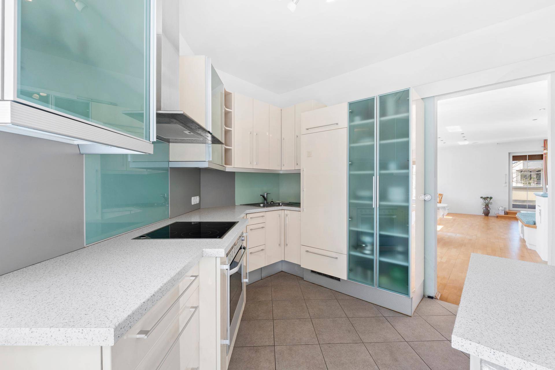 Funktionale Küche mit hellen Schränken, modernen Geräten und praktischem Fliesenboden.