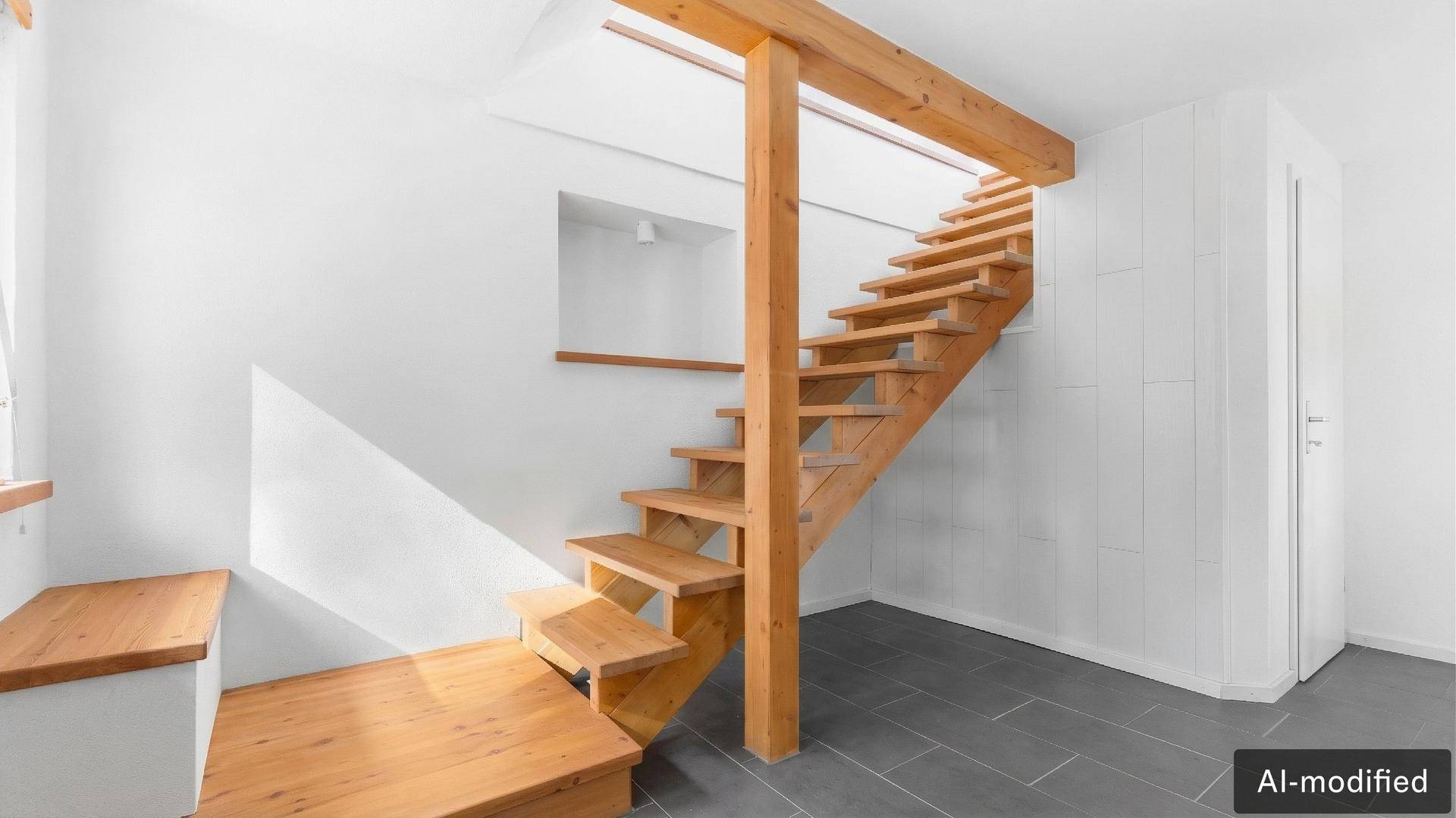 Heller Flur mit offener Holztreppe und weiß gestrichenen Wänden.