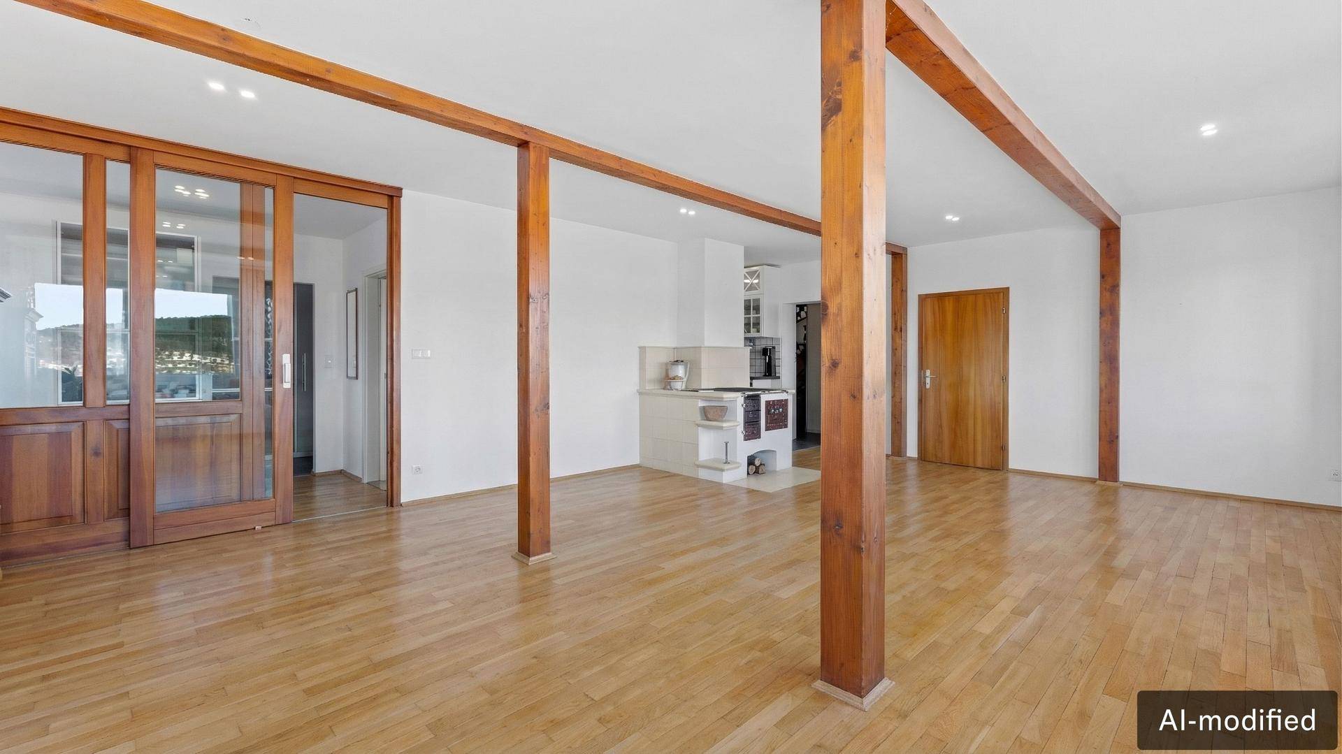 Heller Wohnraum mit Holzbalken, Parkettboden und einem traditionellen Kachelofen im Hintergrund.