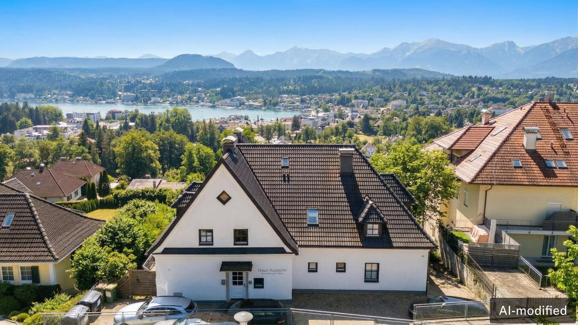Vorderansicht des Hauses mit Satteldach und Blick auf den Wörthersee und die Berge.