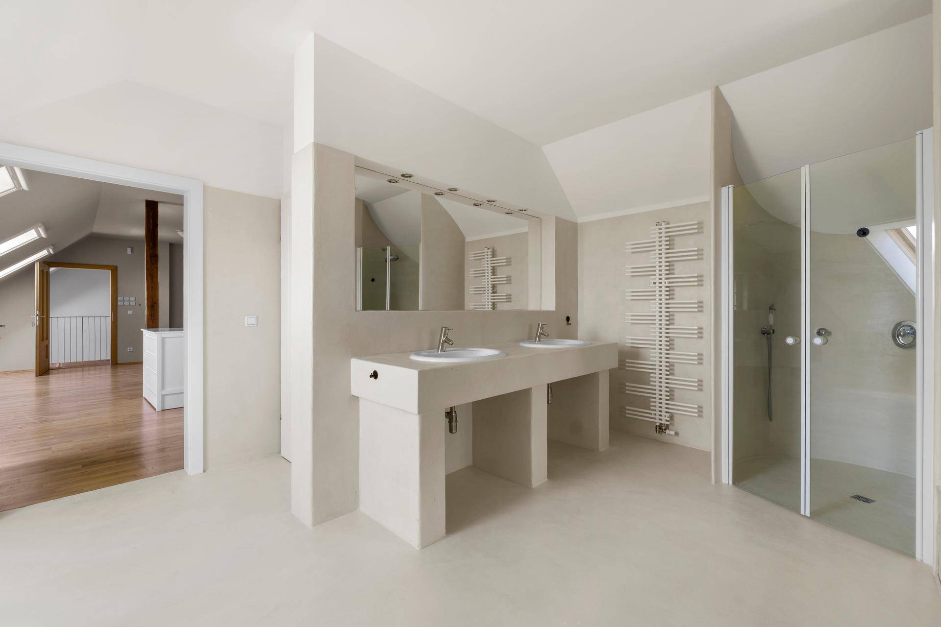 Geräumiges Badezimmer mit Doppelwaschbecken, großer Spiegelfläche und begehbarer Dusche.