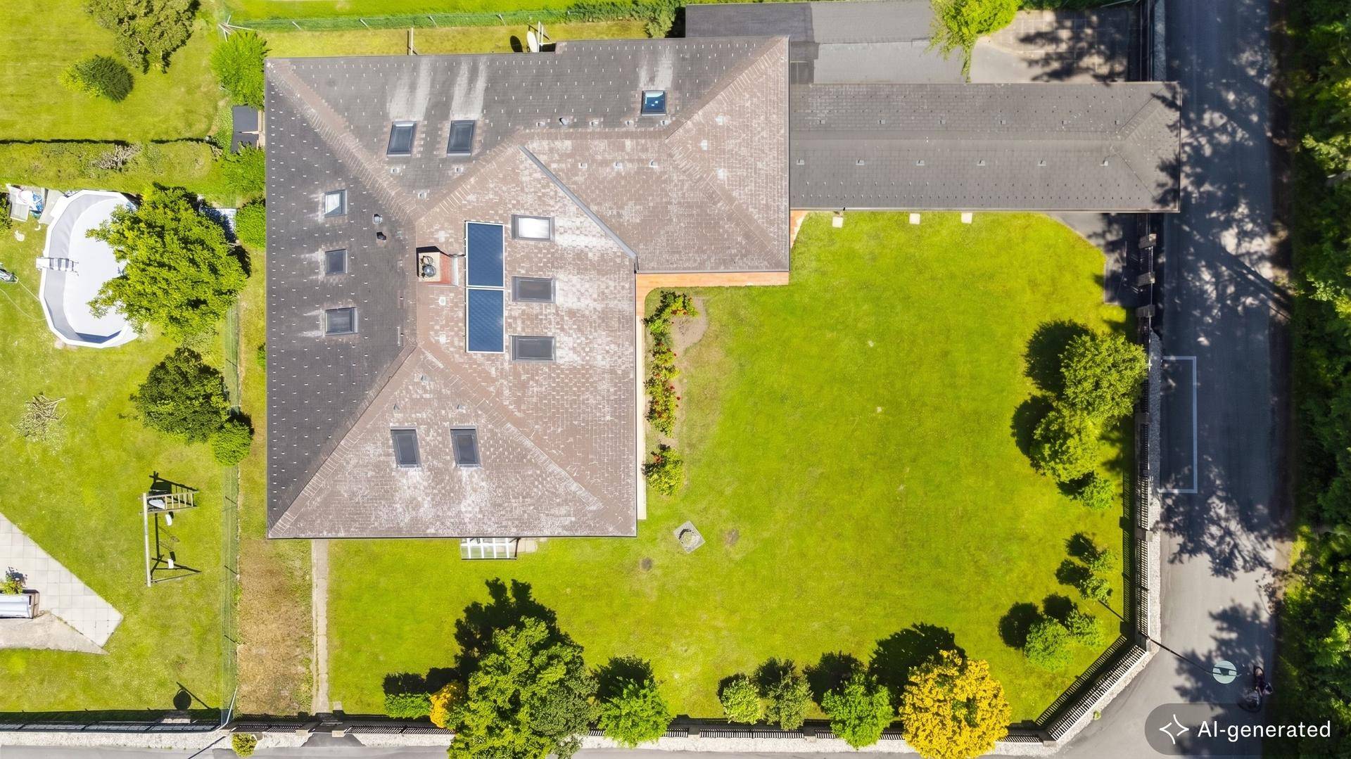 Draufsicht des Grundstücks mit Haus, Garten, Carport und Photovoltaikanlage auf dem Dach.