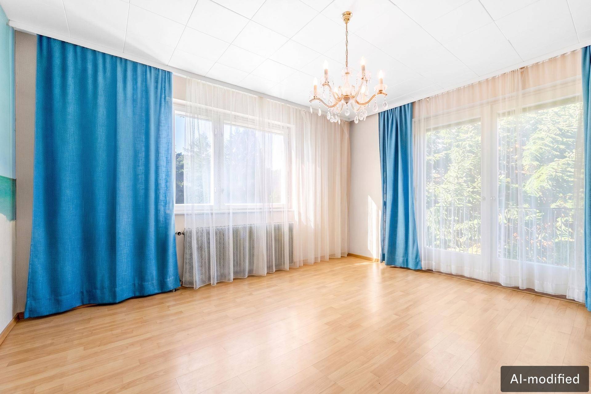 Lichtdurchfluteter Raum mit Parkettboden, großen Fenstern und blauen Vorhängen.