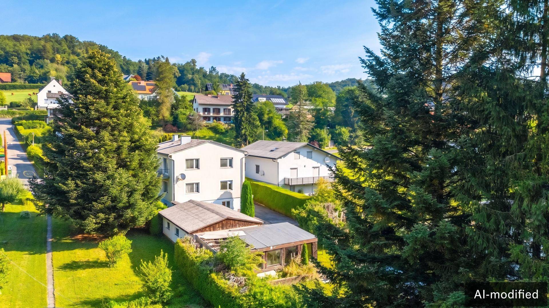 Luftaufnahme des Anwesens mit Nebengebäuden und der umliegenden grünen Landschaft.