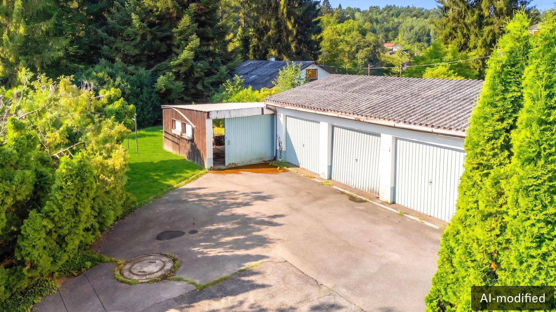 Mehrere Garagen und ein kleiner Schuppen auf dem Grundstück, umgeben von Bäumen.