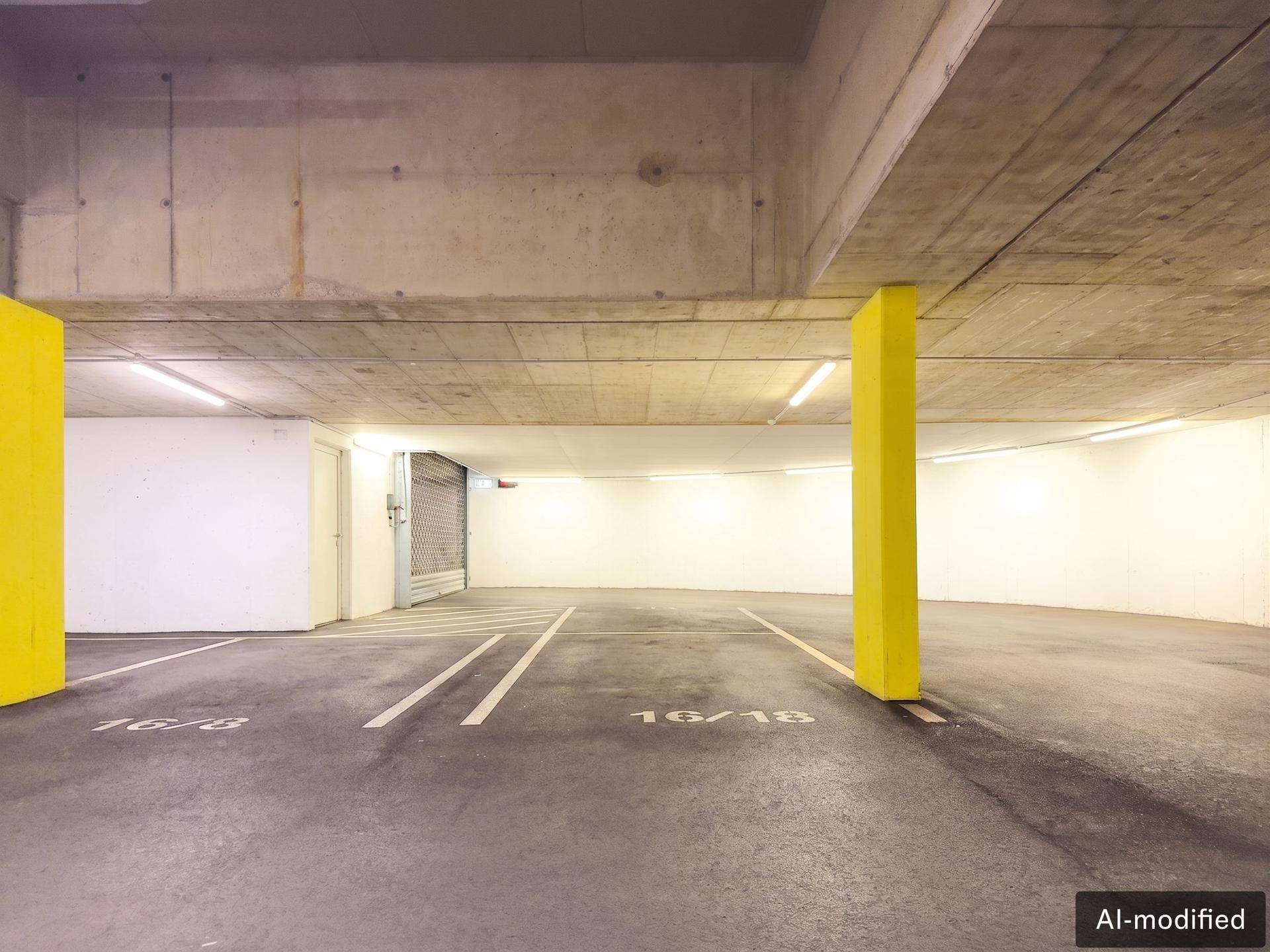 Geräumige Tiefgarage mit Betonwänden und gelben Säulen, bietet ausreichend Parkplätze.