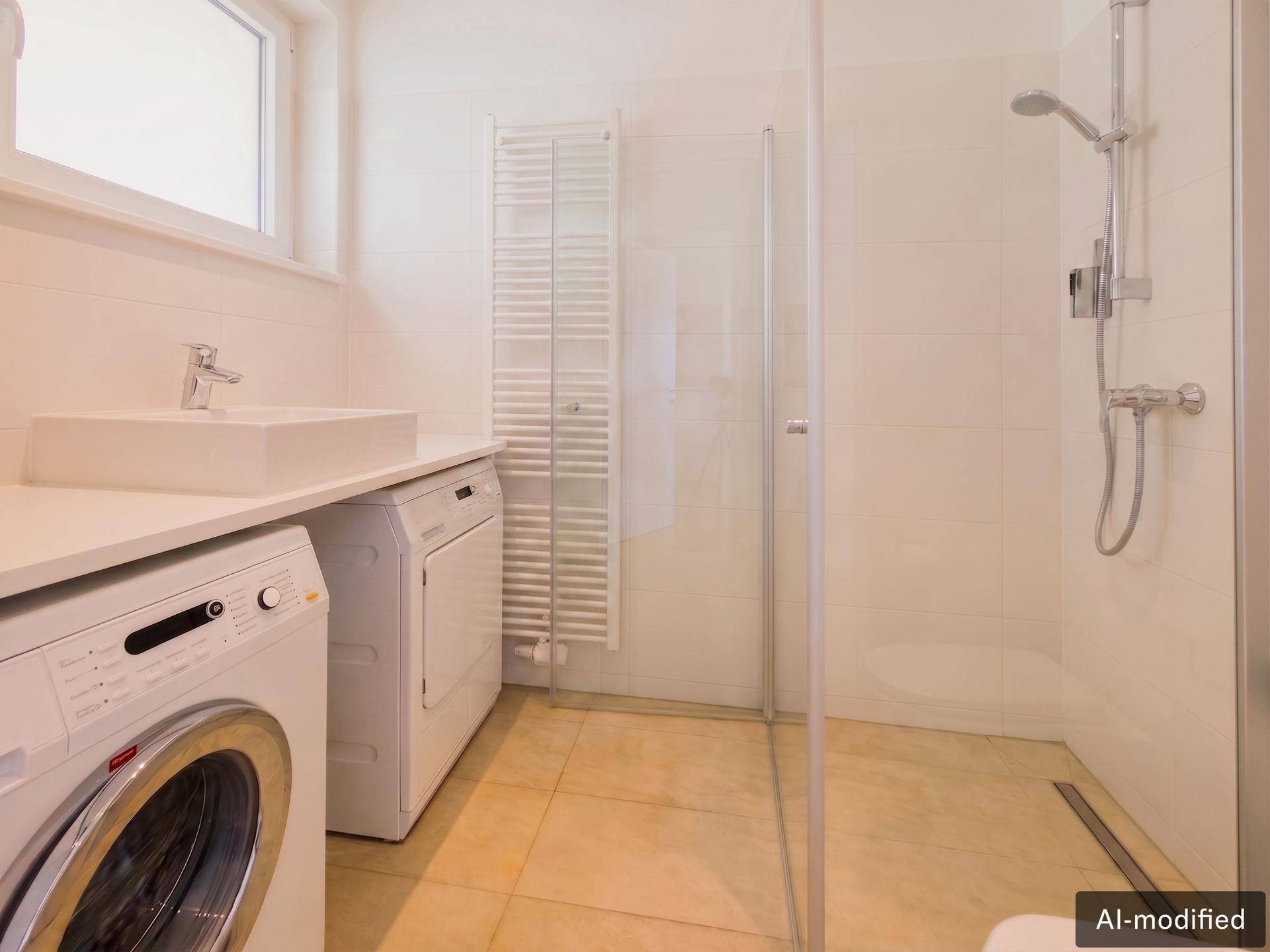 Modernes Badezimmer mit Dusche, Waschbecken, Waschmaschine und Trockner.