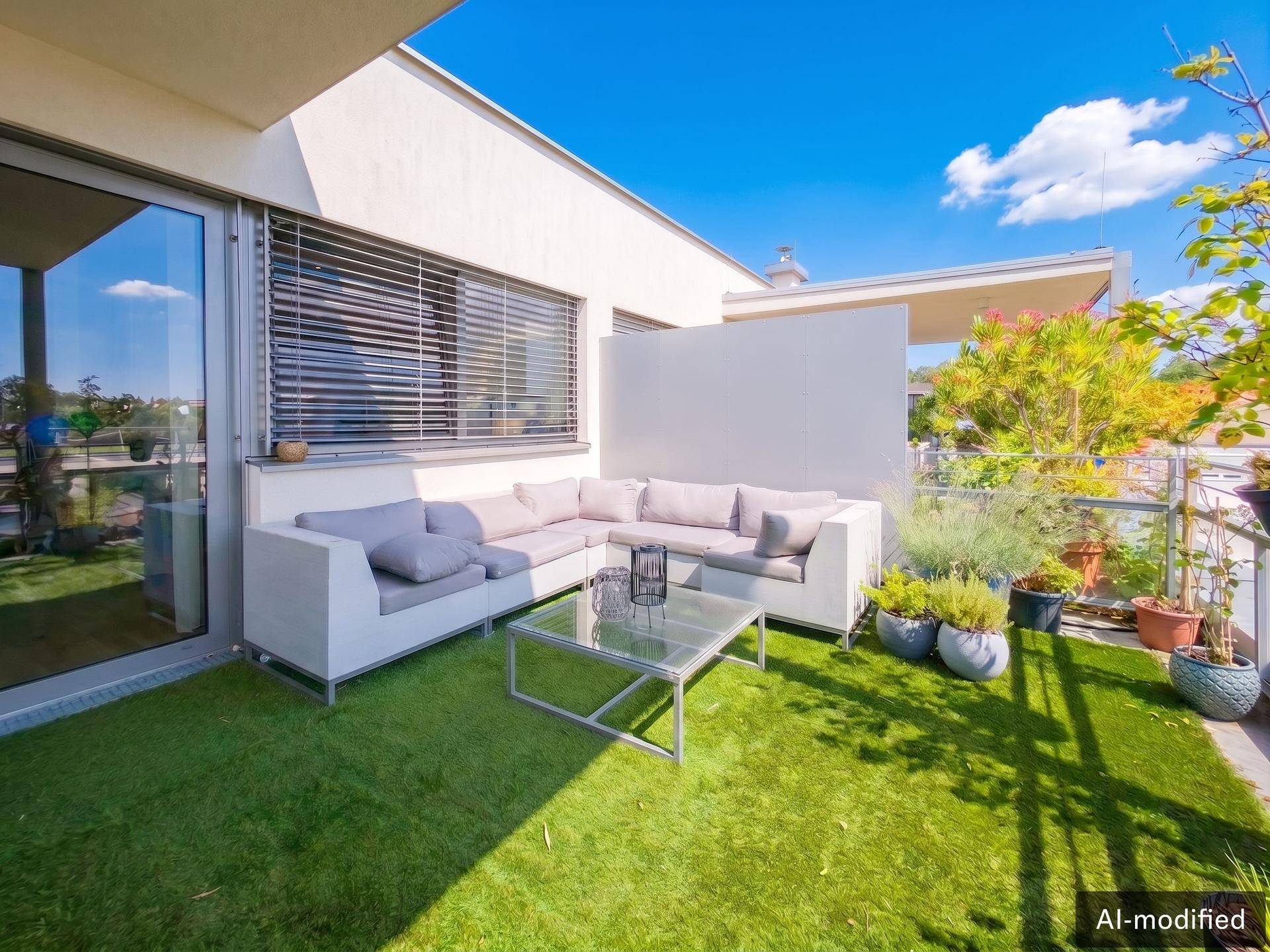 Gemütliche Ecke der Dachterrasse mit L-förmigem Sofa und Pflanzen.