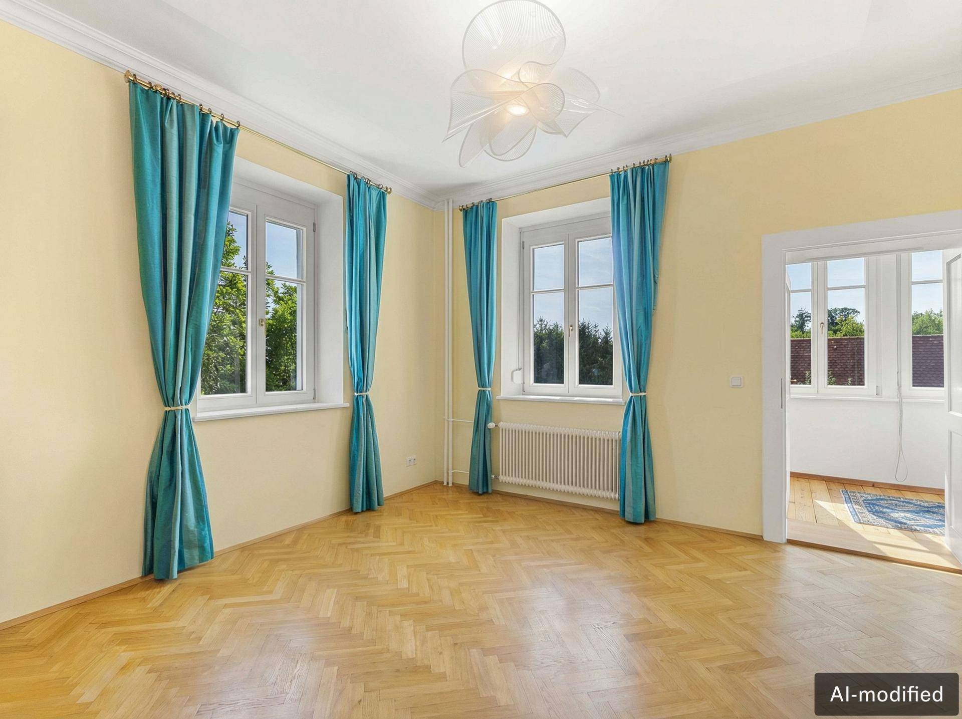 Helles Zimmer mit klassischem Fischgrätparkett, hohen Decken und blauen Vorhängen, ideal als Wohnbereich.