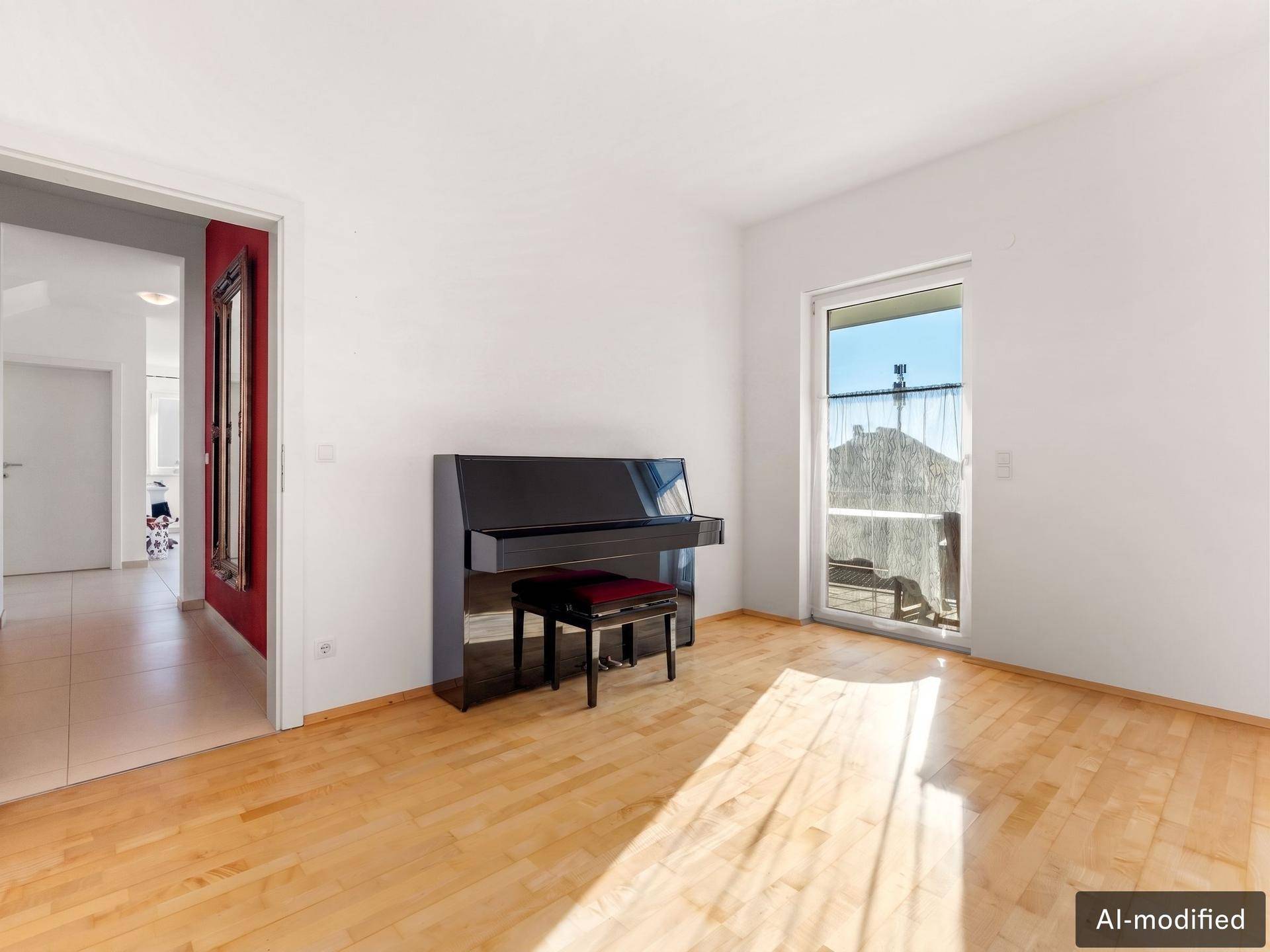 Helles Zimmer mit Parkettboden, Klavier und Zugang zu einem französischen Balkon.
