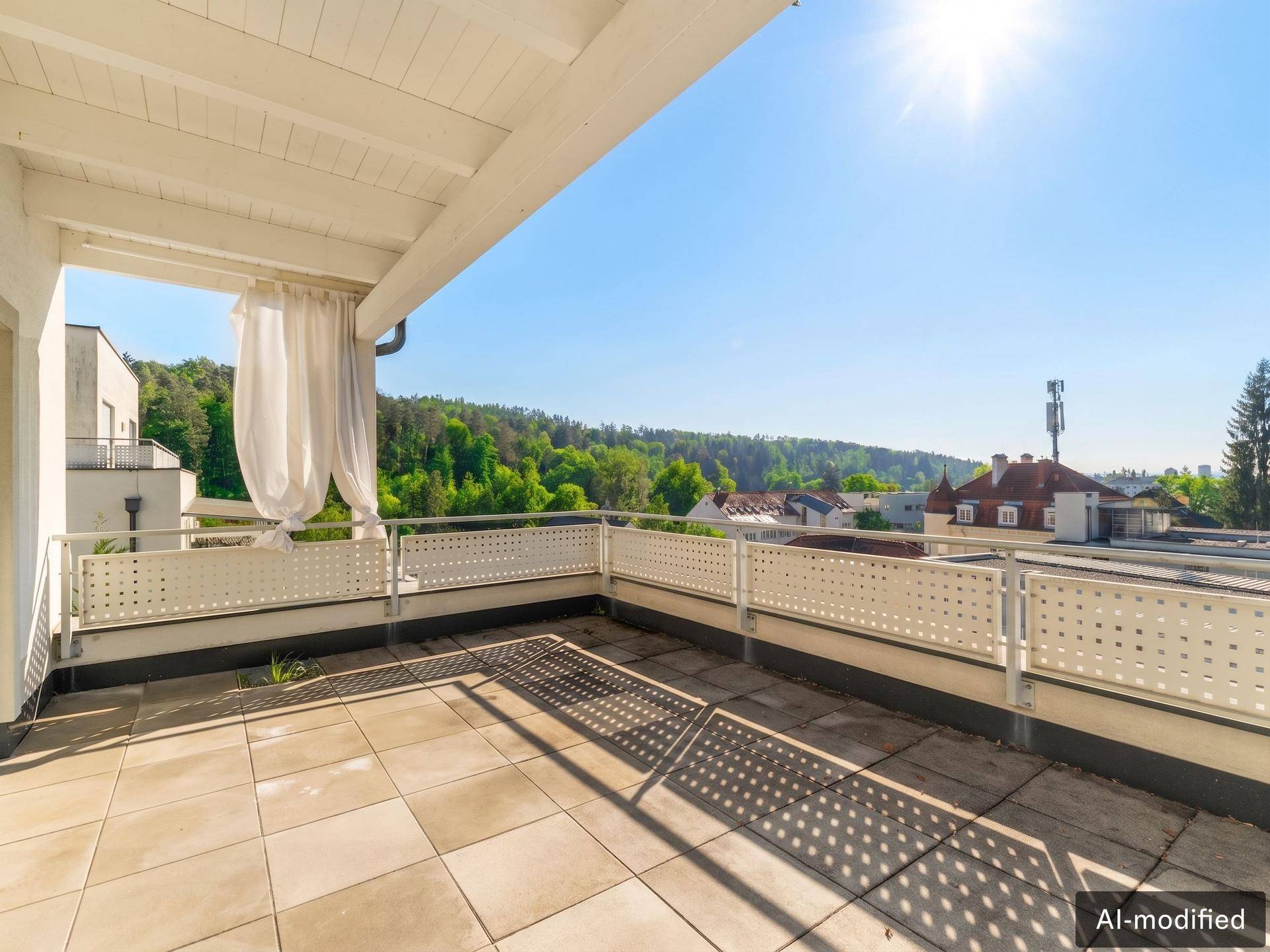Sonnige Dachterrasse mit weitem Ausblick und viel Platz zum Entspannen, umgeben von Natur.