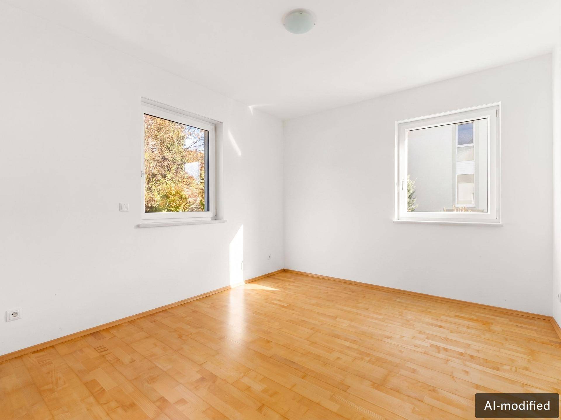 Helles Zimmer mit Holzparkettboden und zwei Fenstern, ideal als Schlaf- oder Arbeitszimmer.