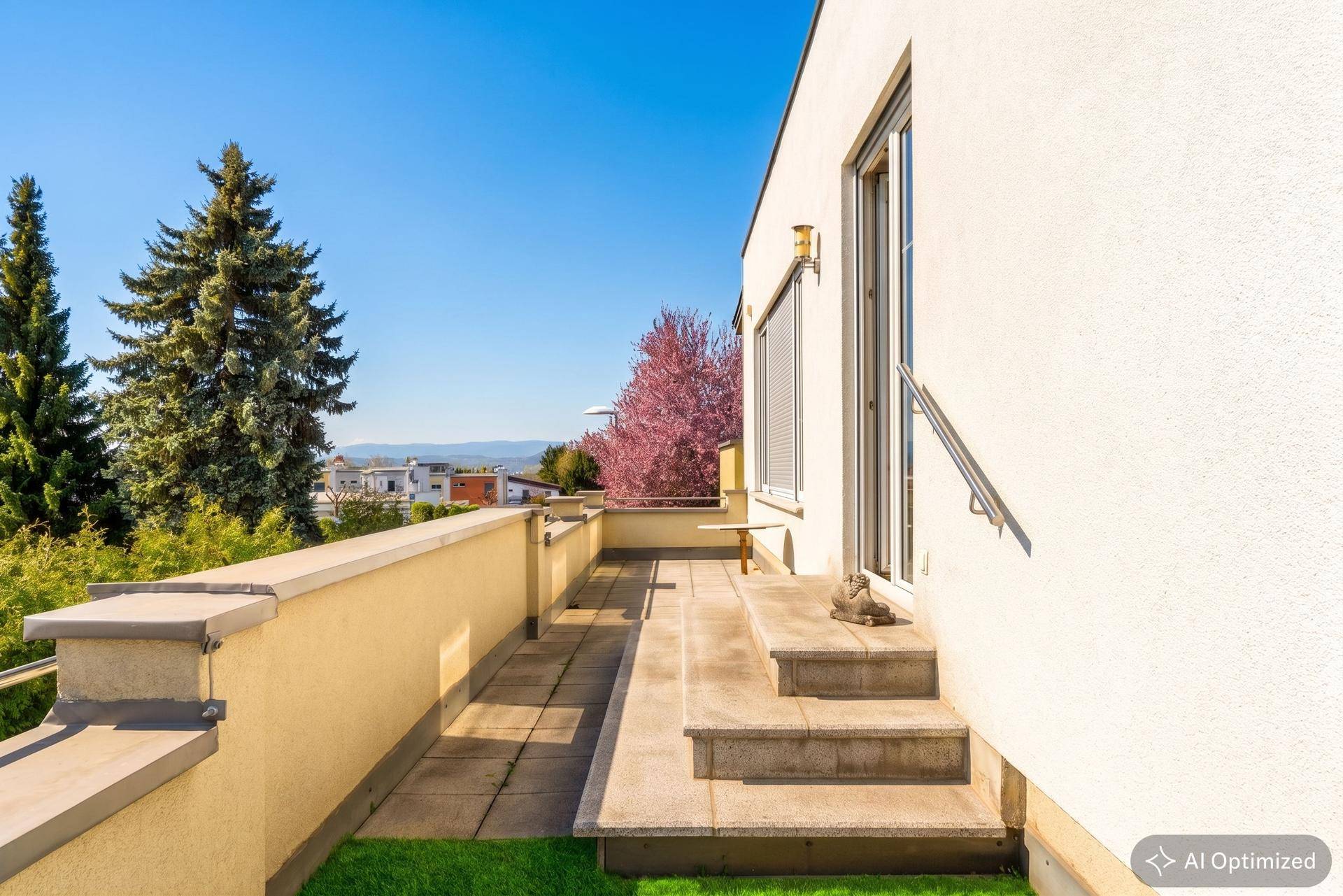 Außenterrasse mit Stufen und Rampe, bietet Zugang zum Gartenbereich und Weitblick.