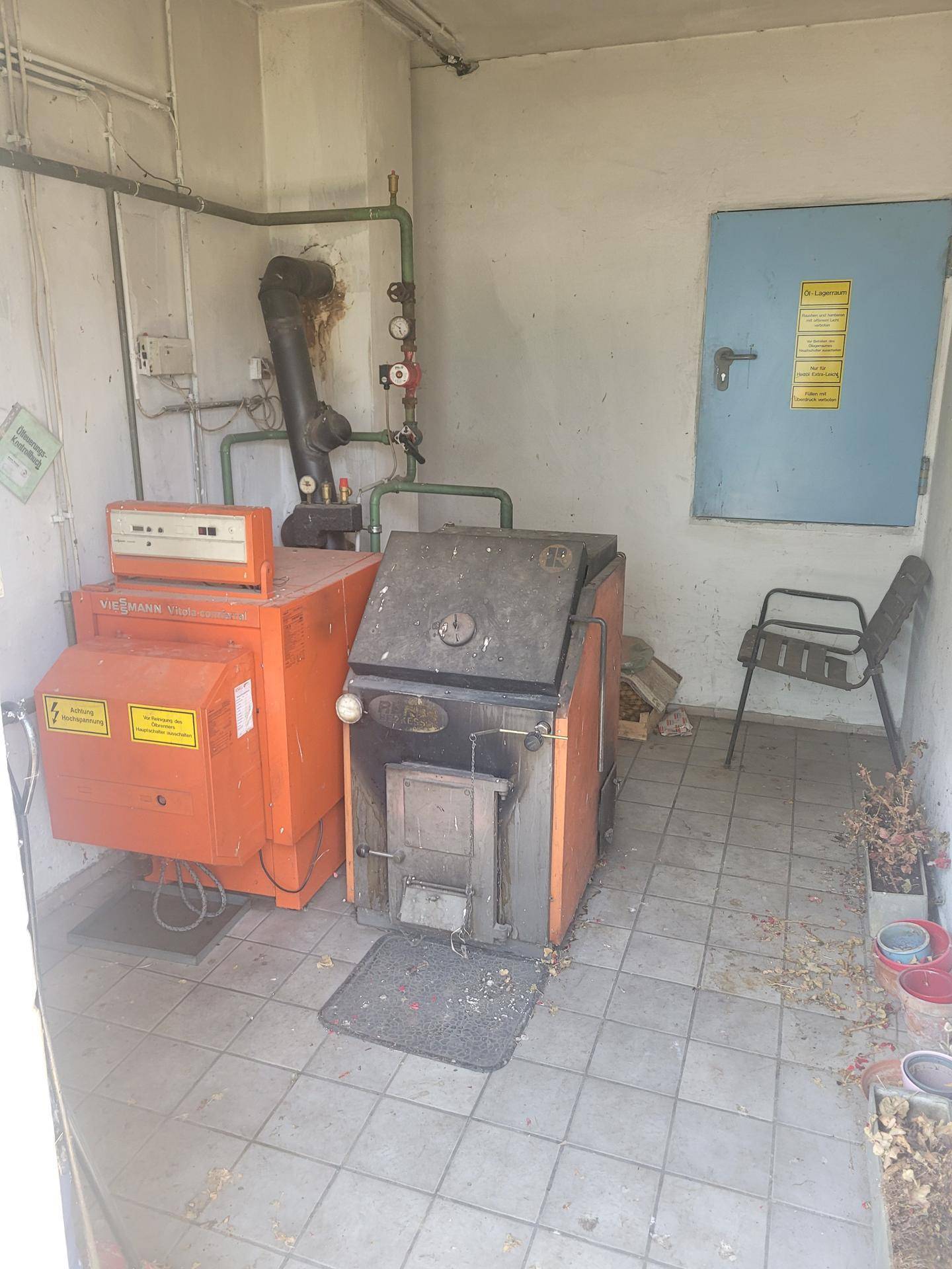 Heizungsraum mit zwei großen Heizkesseln und Fliesenboden, bereit für den Betrieb.