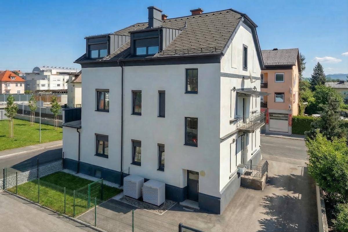 Rückansicht des Gebäudes mit kleinem Gartenbereich, Außenanlagen und Blick auf die Umgebung.