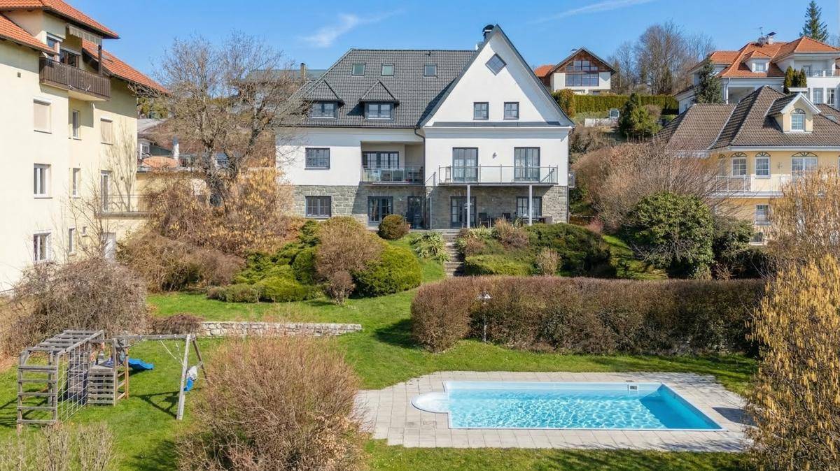 Rückansicht des Hauses mit großem Garten, Swimmingpool und Kinderspielplatz.