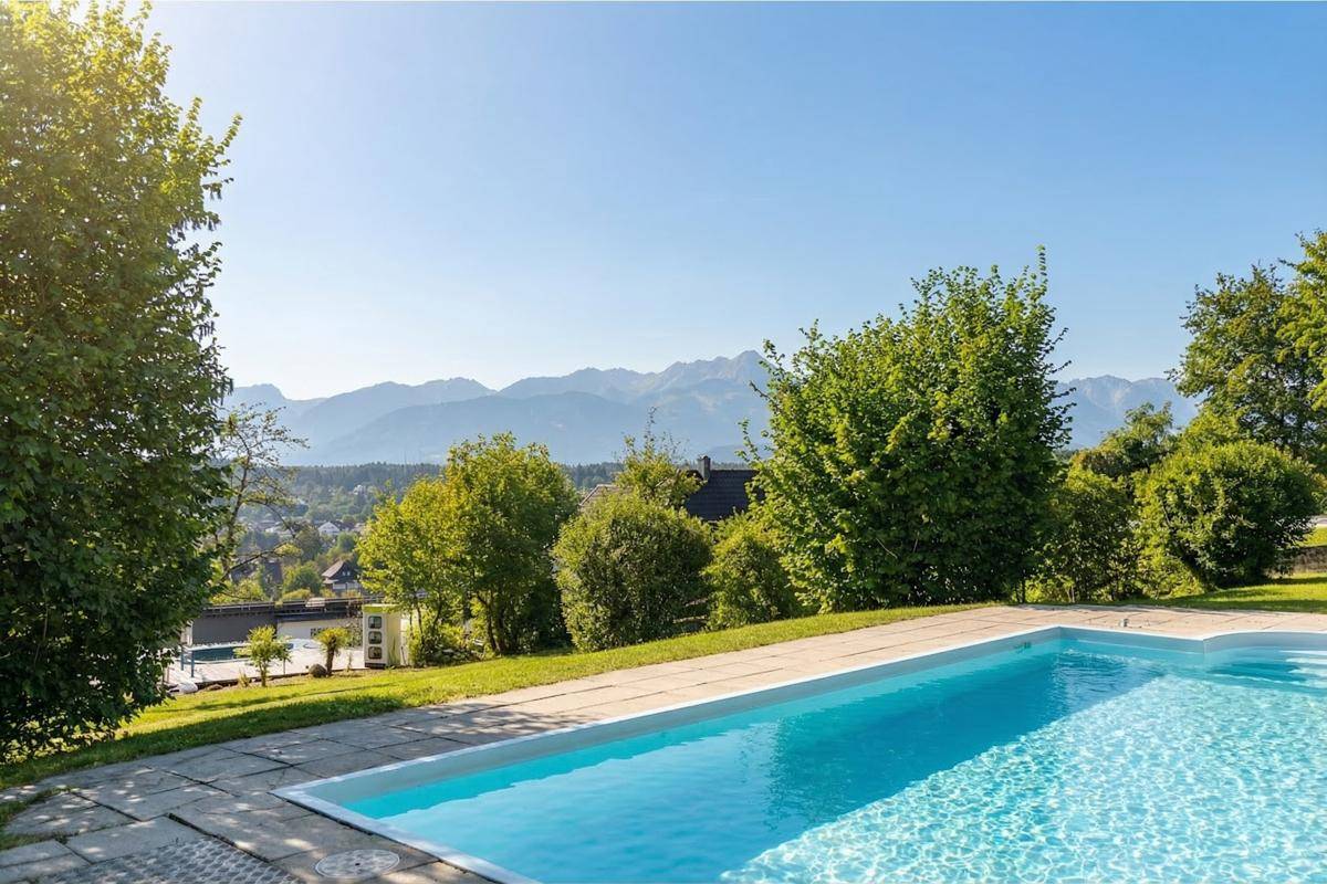 Großer Swimmingpool im Gartenbereich mit weitem Blick auf die Berge.