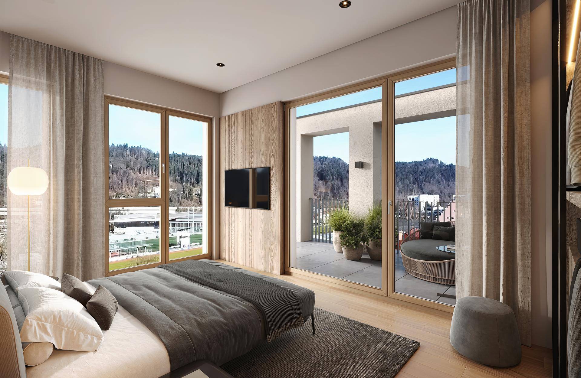 Helles Schlafzimmer mit Holzboden, großen Fenstern und direktem Zugang zum Balkon.