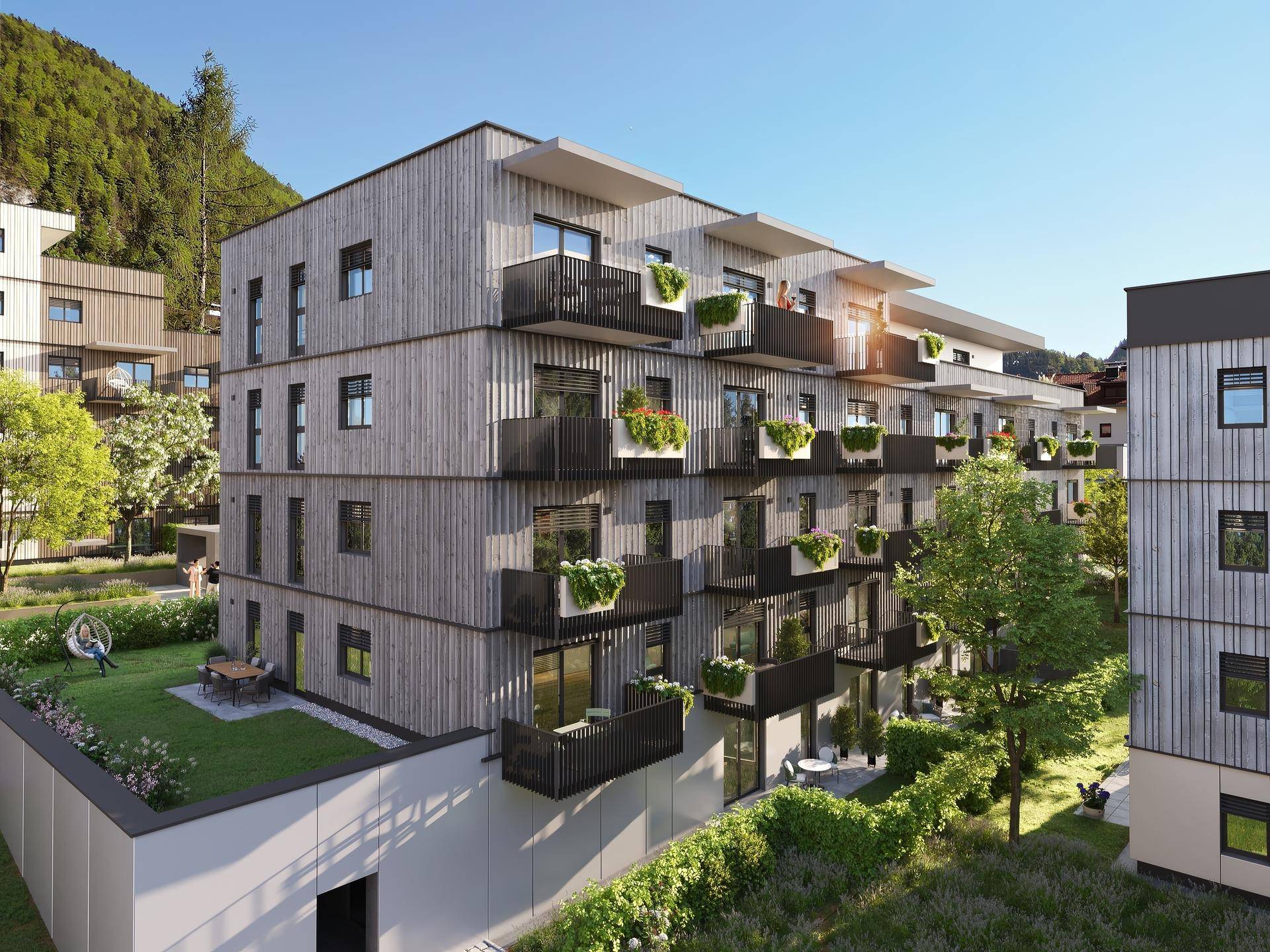 Ansicht der modernen Wohngebäude mit Holzfassade und zahlreichen Balkonen in grüner Umgebung.