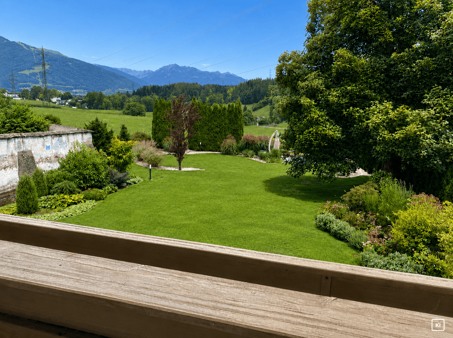 Weitläufiger Garten mit Bergblick und grüner Landschaft, aufgenommen von einem Balkon.