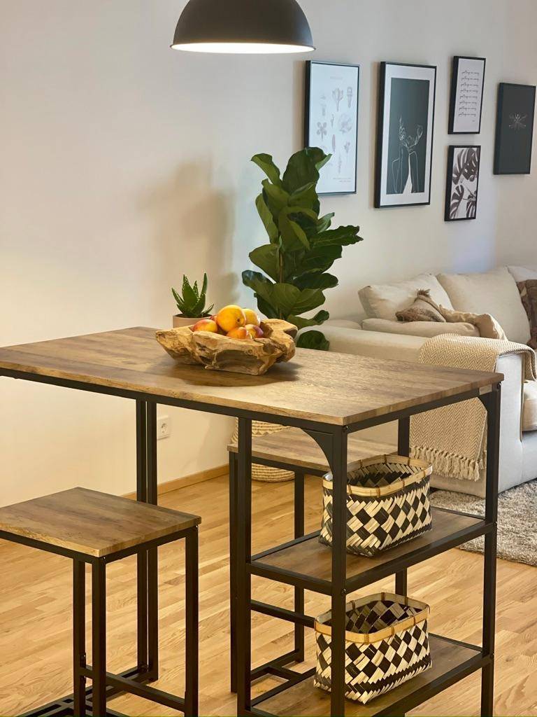 Offener Wohnbereich mit Esstisch, bequemer Couch und stilvoller Wanddekoration.