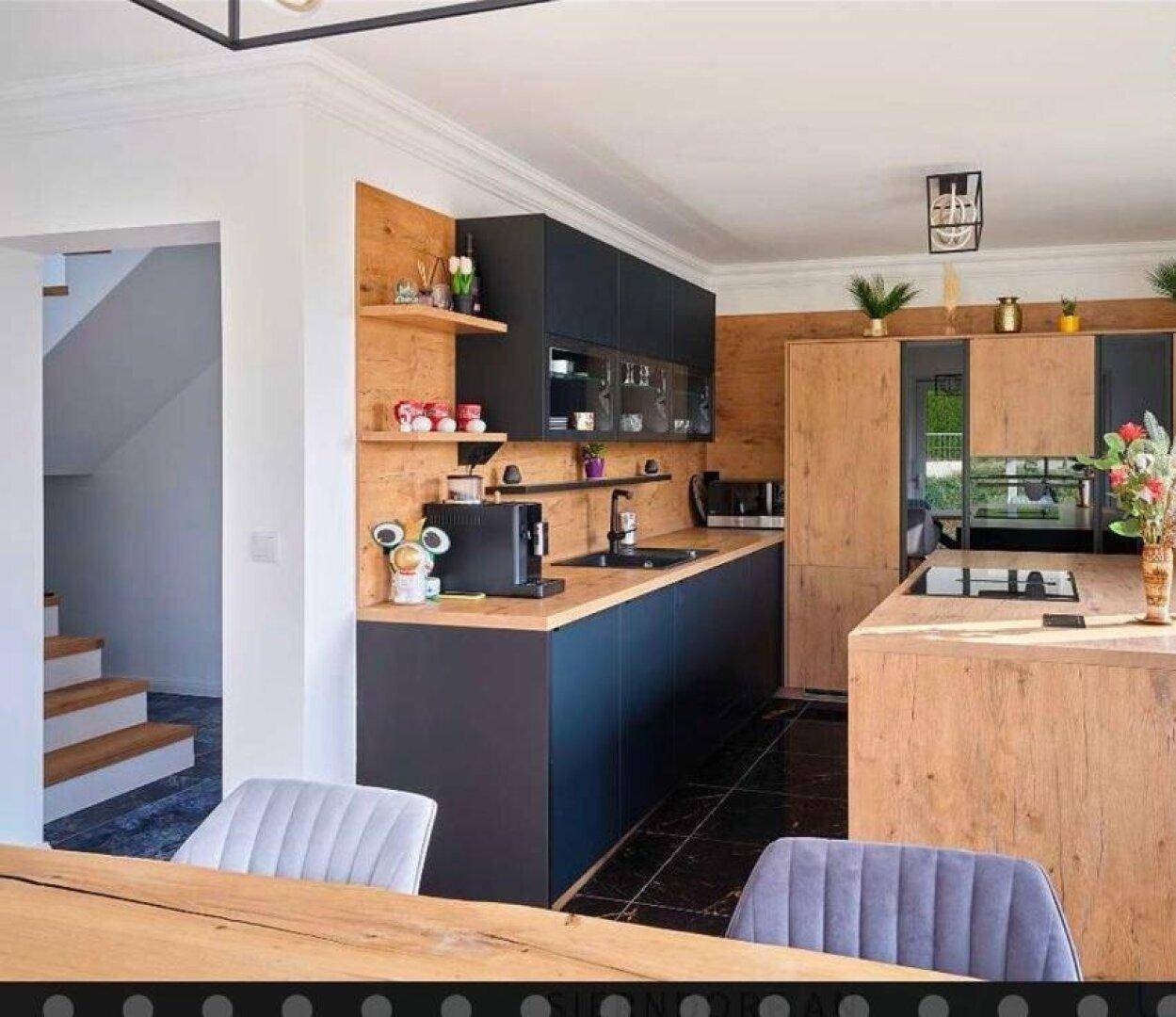 Moderne Küche mit dunklen Schränken, Holzakzenten und integrierten Geräten.