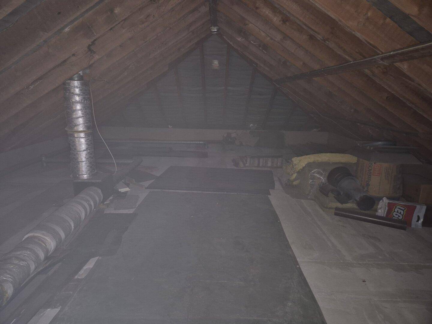 Geräumiger Dachboden mit sichtbarer Holzkonstruktion und Isolierung, ideal als Abstellfläche.