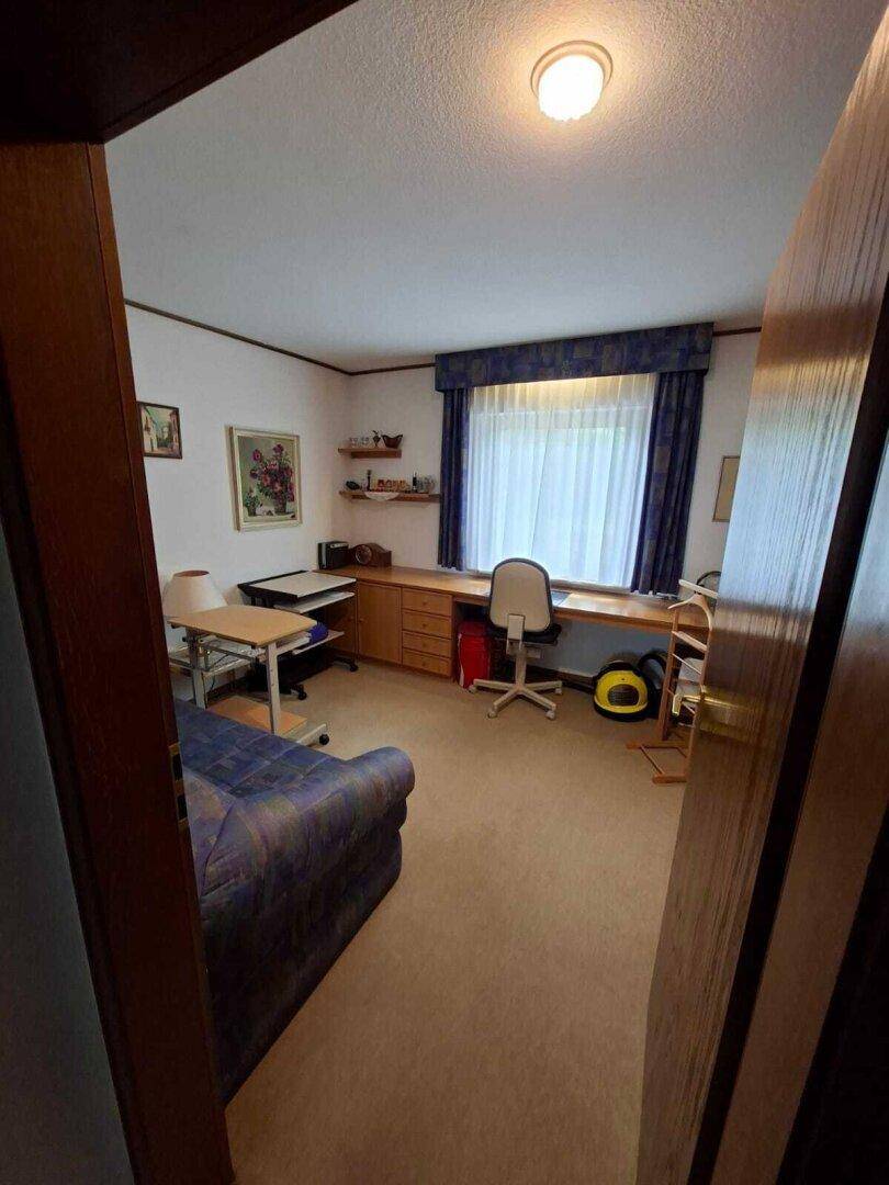 Arbeitszimmer mit Schreibtisch und Sofa, ideal für Home-Office oder als zusätzliches Schlafzimmer.