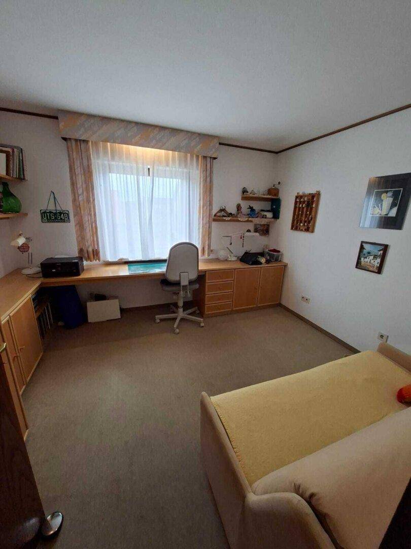 Helles Arbeitszimmer mit Schreibtisch, Teppichboden und Blick ins Grüne, auch als Gästezimmer nutzbar.