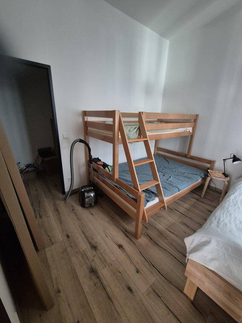 Schlafzimmer mit Etagenbett und Holzboden, bietet Platz für mehrere Personen.