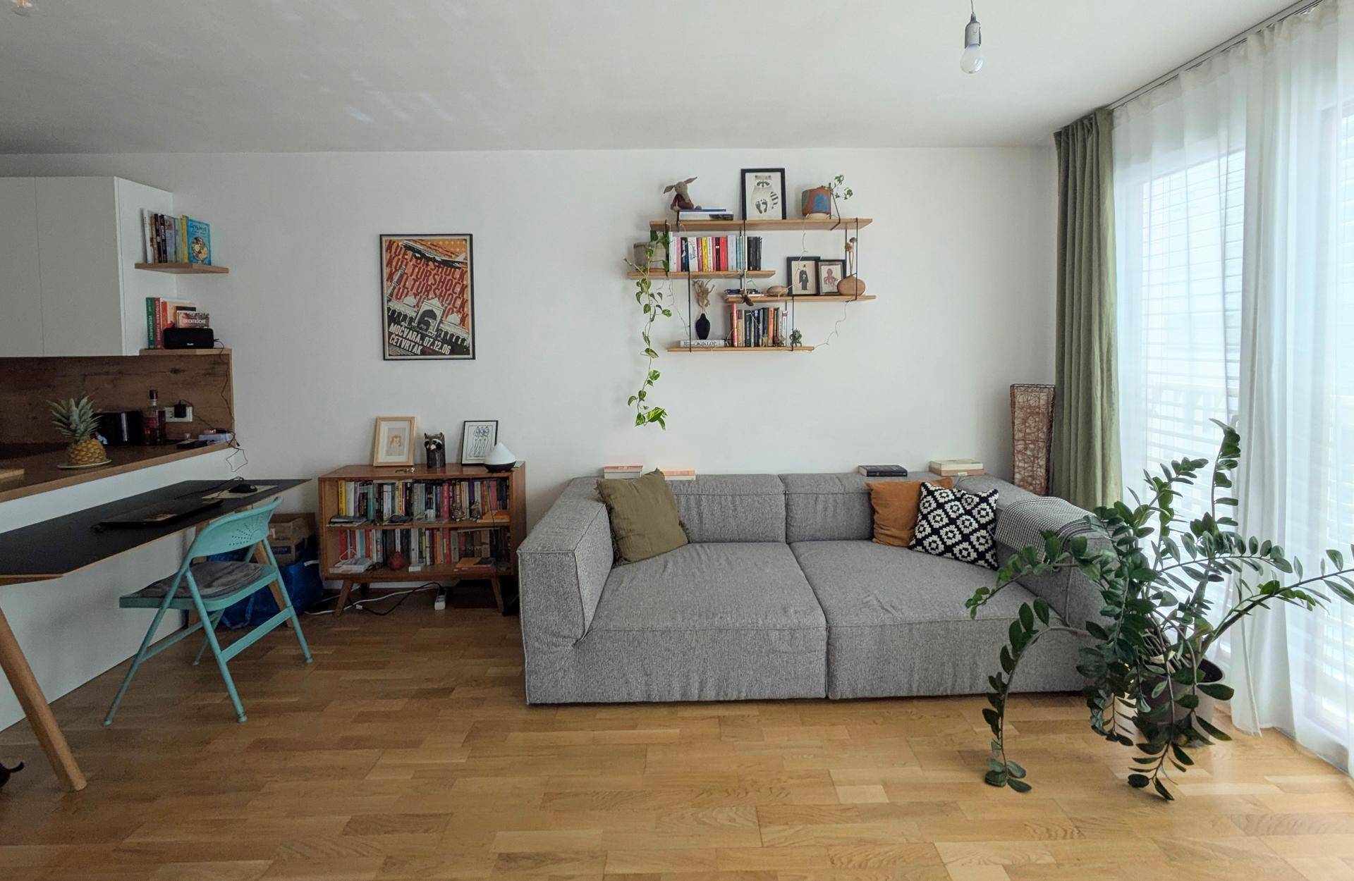 Gemütlicher Wohnbereich mit großem Ecksofa, Bücherregalen und viel Tageslicht.