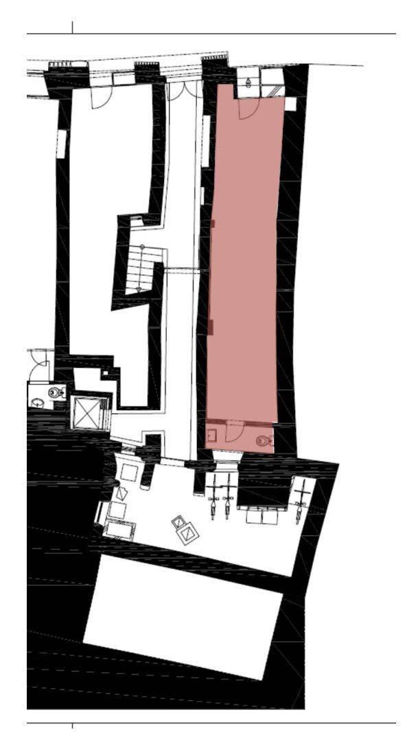 Grundriss eines Gebäudes mit verschiedenen Räumen, Treppen und einem hervorgehobenen Bereich.