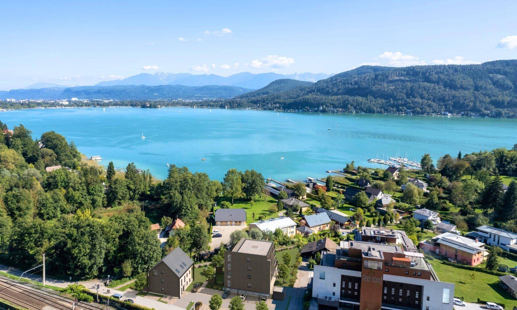 Panoramablick aus der Vogelperspektive auf einen großen See, umgeben von Hügeln und Siedlungen.