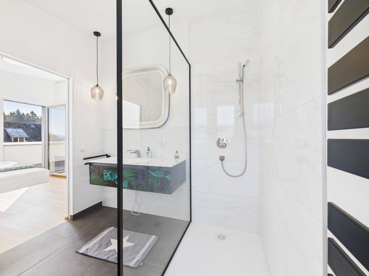 Modernes Badezimmer mit begehbarer Dusche, stilvollem Waschtisch und viel Tageslicht.