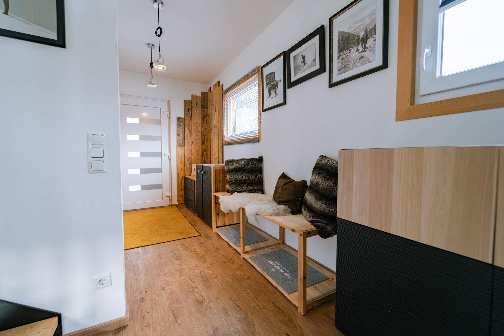 Eingangsbereich mit Holzboden, Garderobe und dekorativen Elementen.