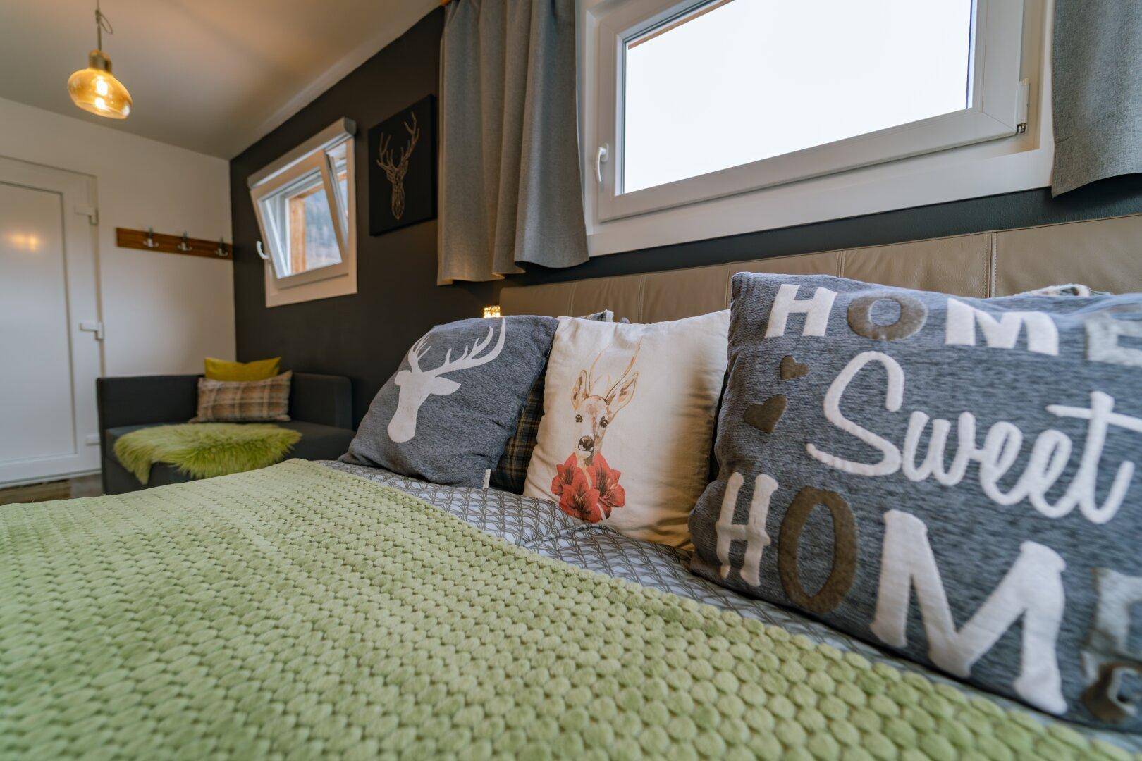 Schlafzimmer mit Doppelbett, Hirschkissen und gemütlicher Atmosphäre.