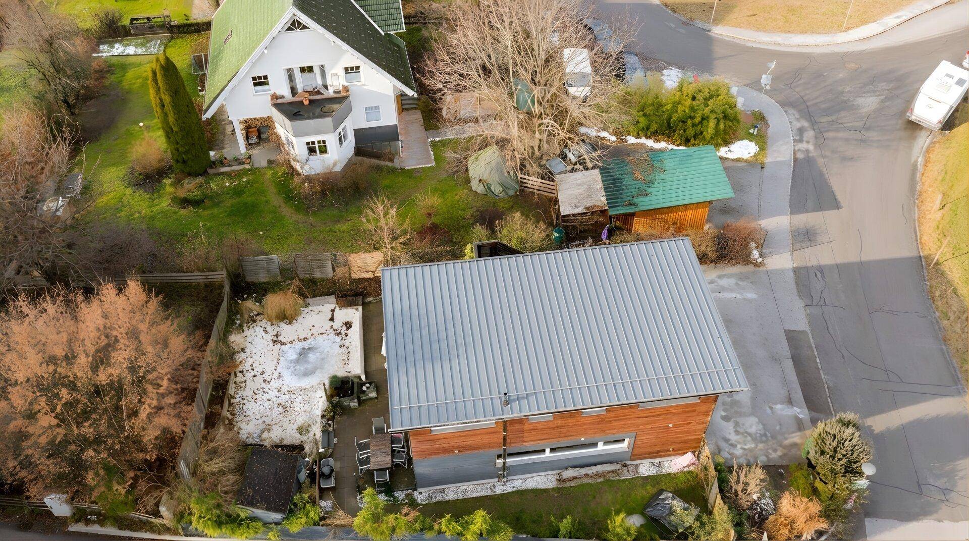 Luftaufnahme eines Hauses mit Garten, Terrasse und umliegender Landschaft.