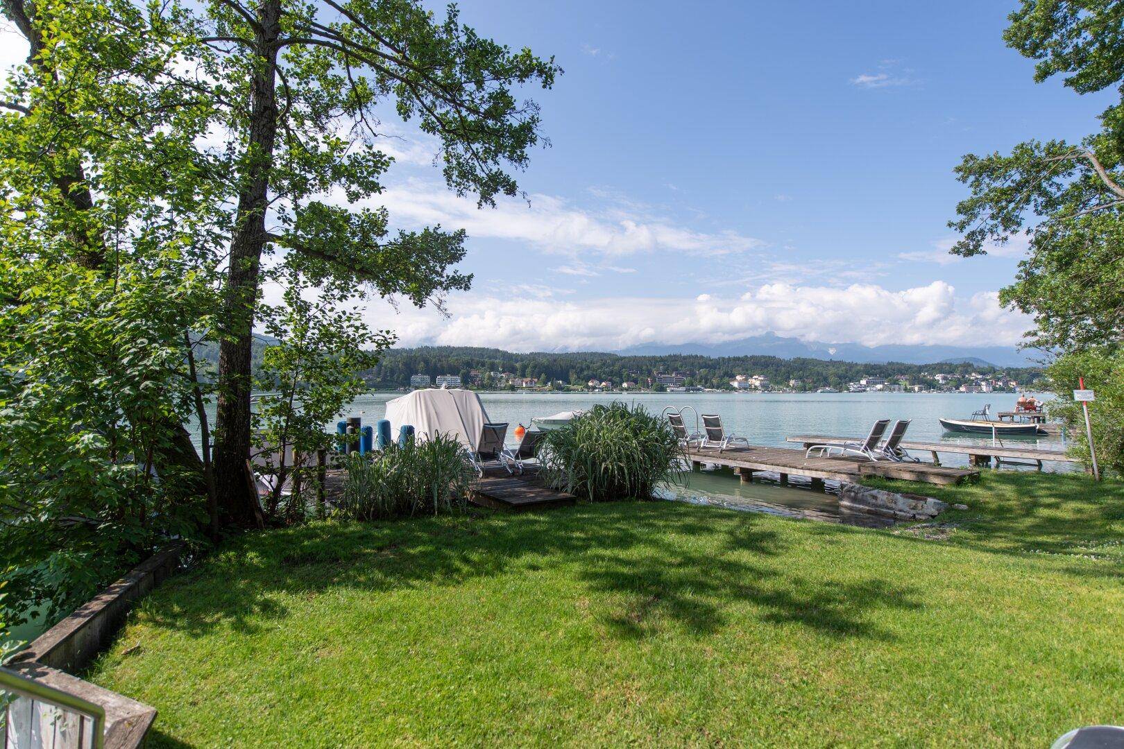Gepflegter Gartenbereich mit direktem Zugang zum Wörthersee und Bootsstegen.
