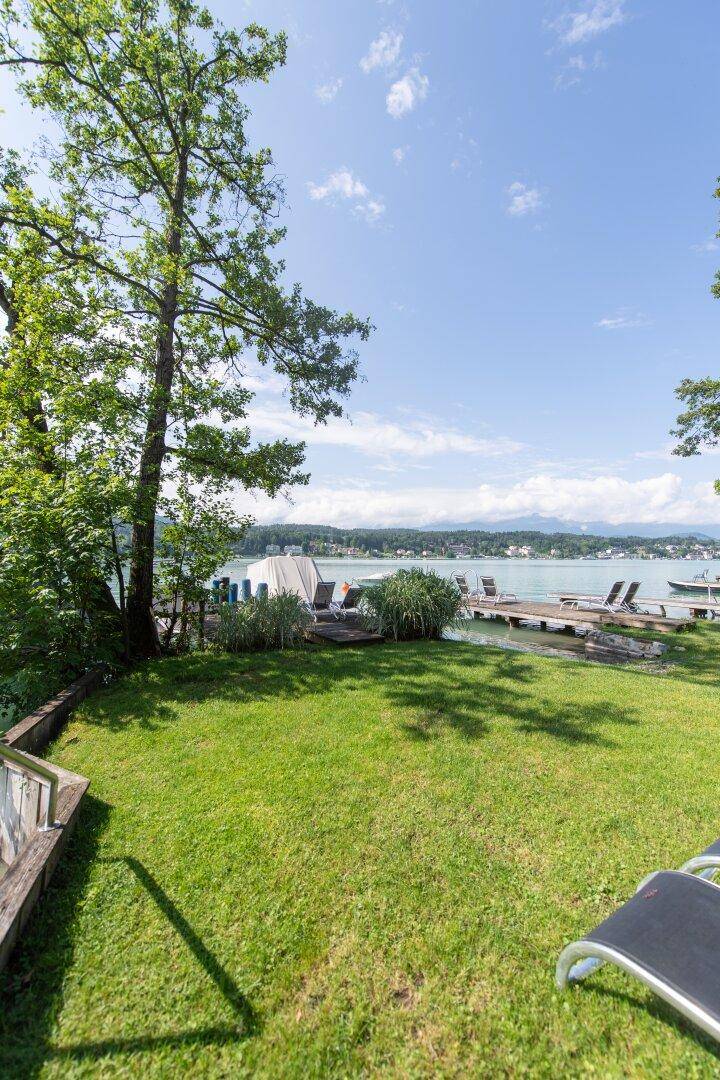 Sonniger Gartenbereich mit Liegestühlen und direktem Zugang zum klaren Wörthersee.