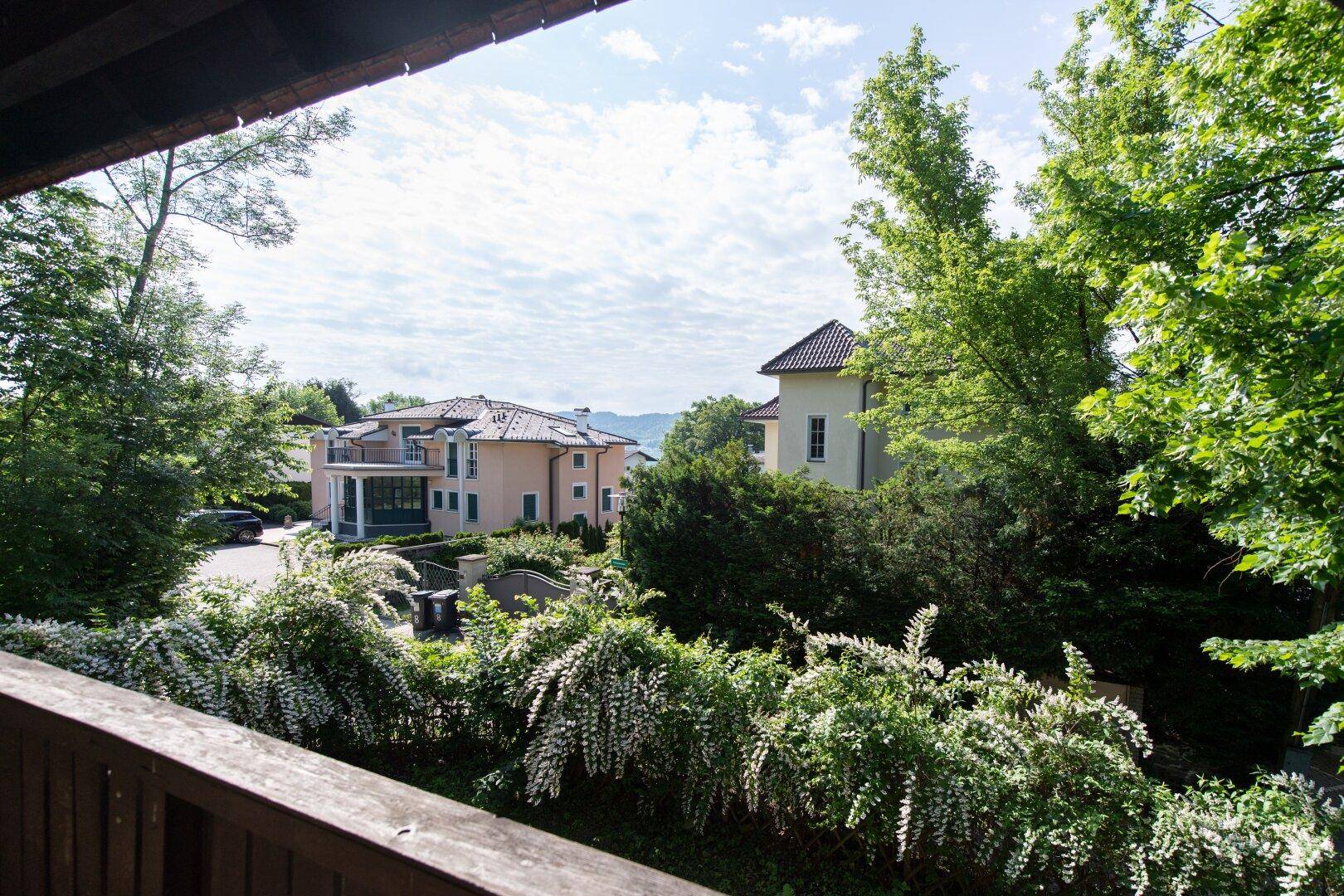 Blick von der Unterkunft auf umliegende Gebäude und üppige grüne Vegetation.