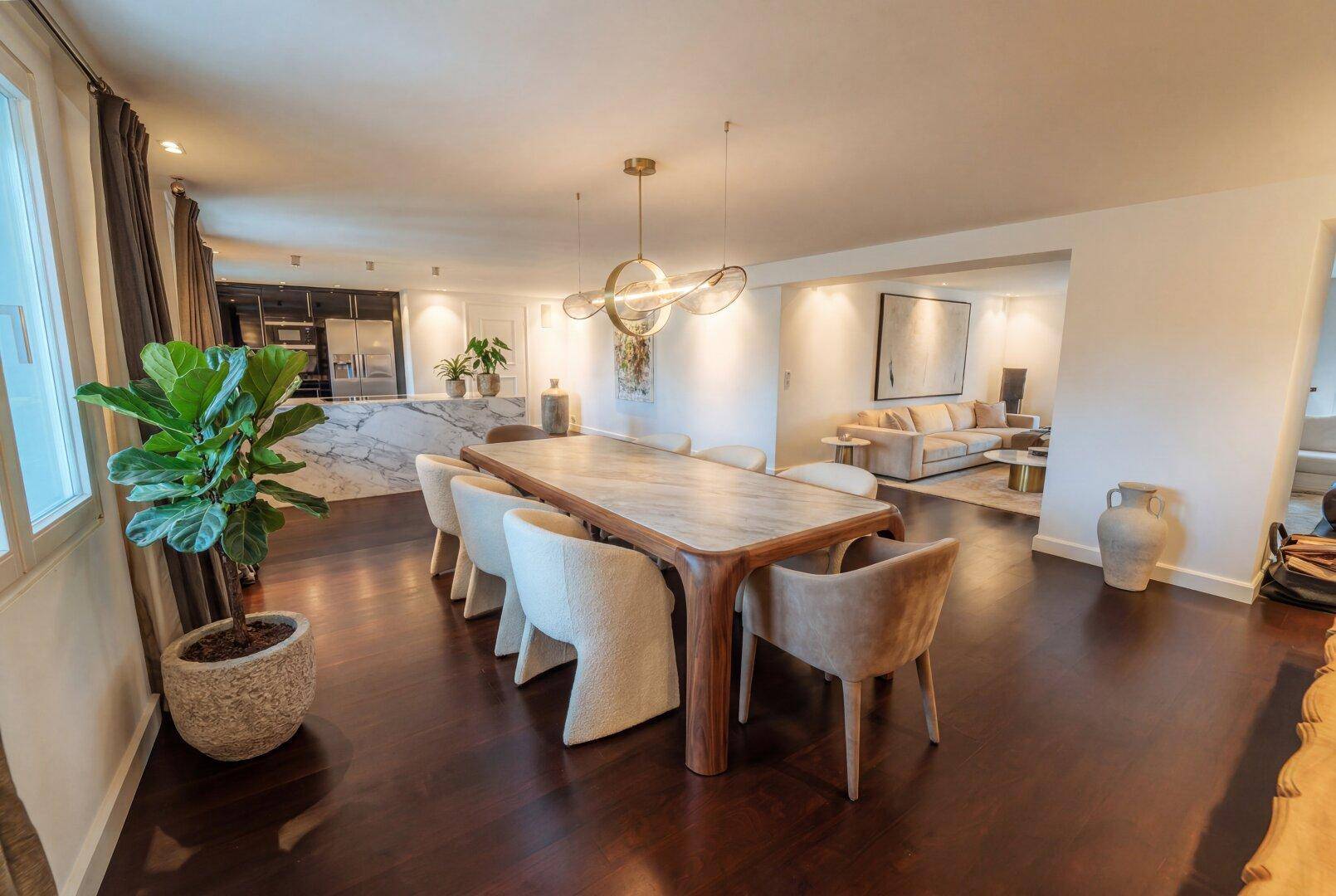 Eleganter Essbereich mit großem Holztisch, modernen Stühlen und offener Gestaltung zum Wohnzimmer.