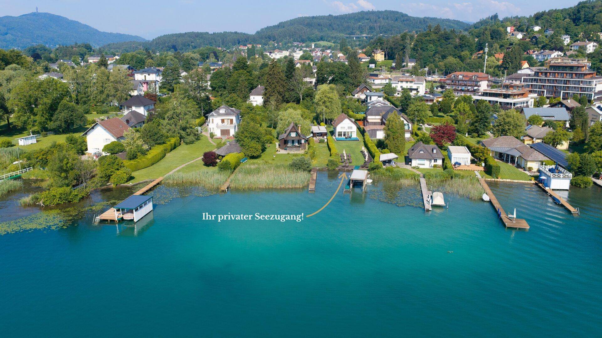Weitläufige Luftaufnahme von Seegrundstücken mit privaten Stegen und exklusivem Zugang zum See.