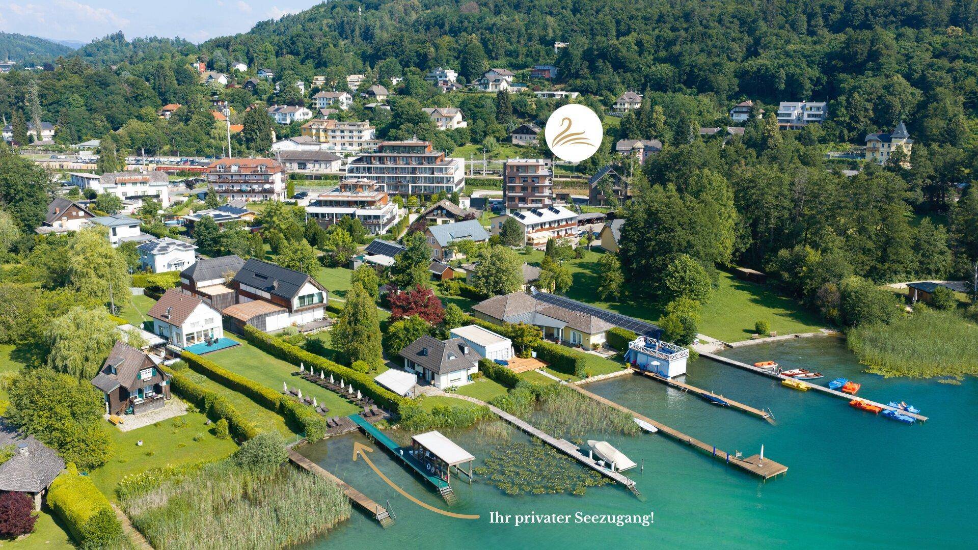 Luftaufnahme einer Wohngegend am Seeufer mit privaten Stegen und direktem Zugang zum Wasser.